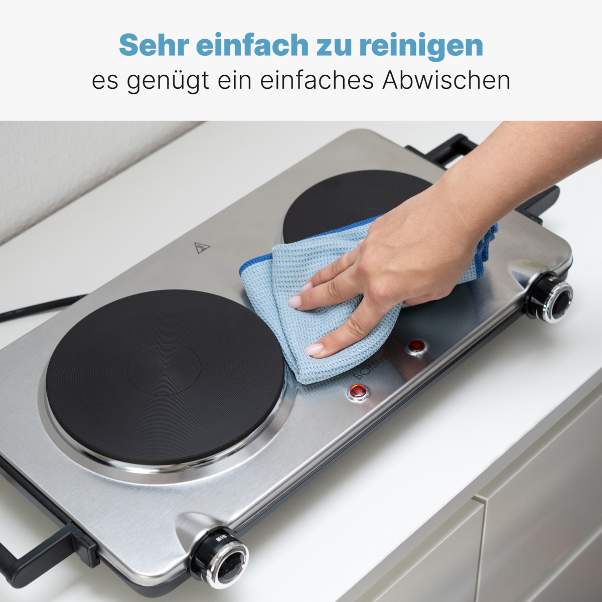 Ręka wyciera podwójną płytę grzewczą niebieską szmatką. Tekst brzmi: 'Bardzo łatwe do czyszczenia'.