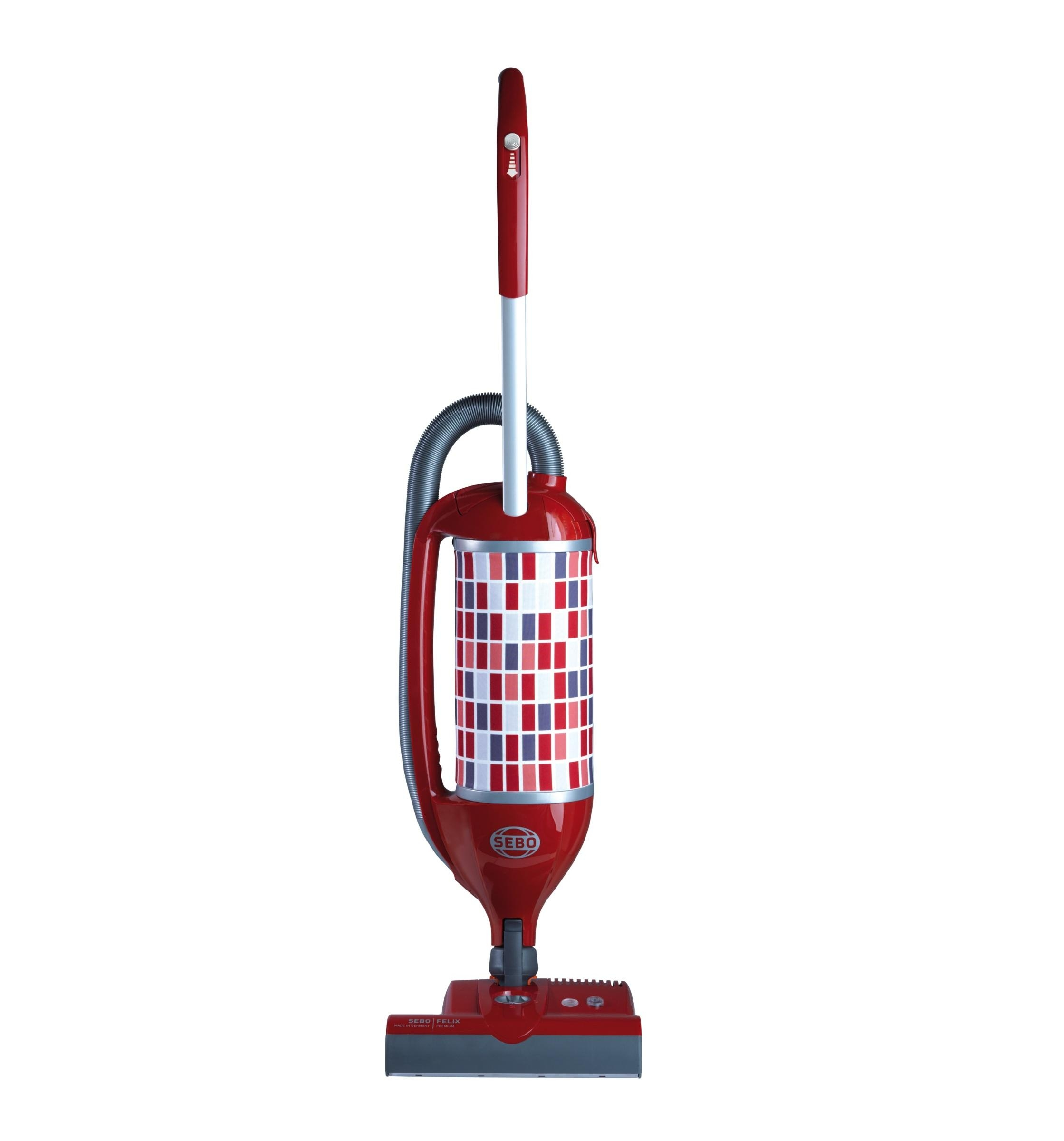 Roter Sebo Staubsauger. Er hat einen zylindrischen Körper mit einem gemusterten Design und einen Schlauch.