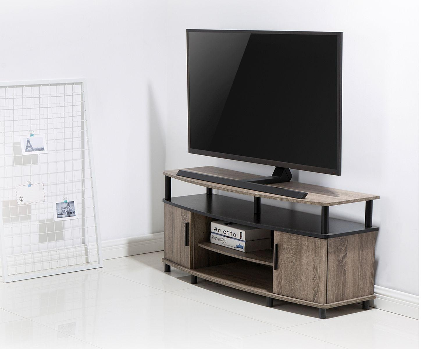 Ein Fernseher auf einem Holzständer. Der Ständer hat zwei Türen. Ein weißes Gitter befindet sich links. Der Boden ist weiß.