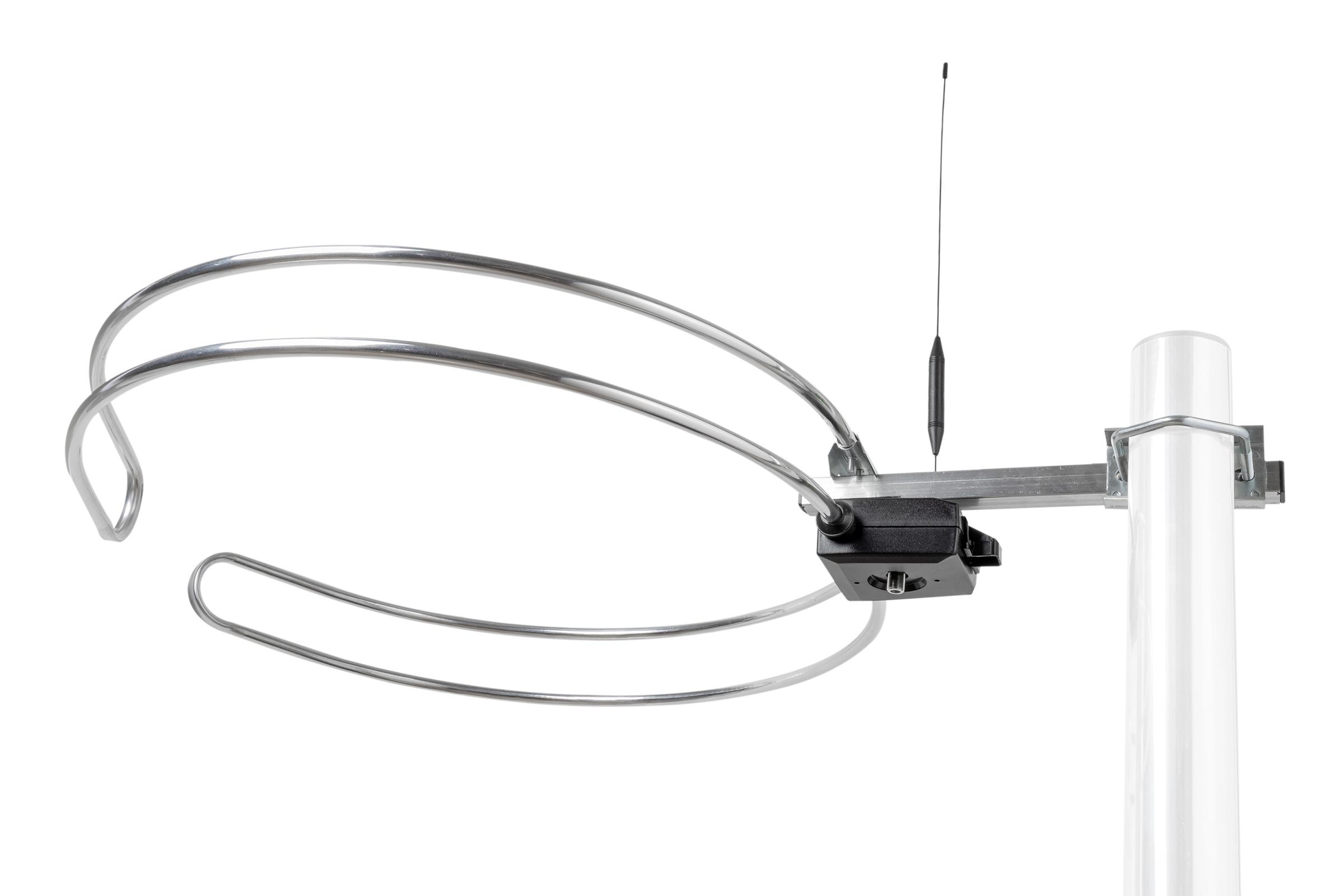 Eine silberne Schleife Antenne mit einem schwarzen Kasten und einer Antenne, an einem weißen Pfosten befestigt.