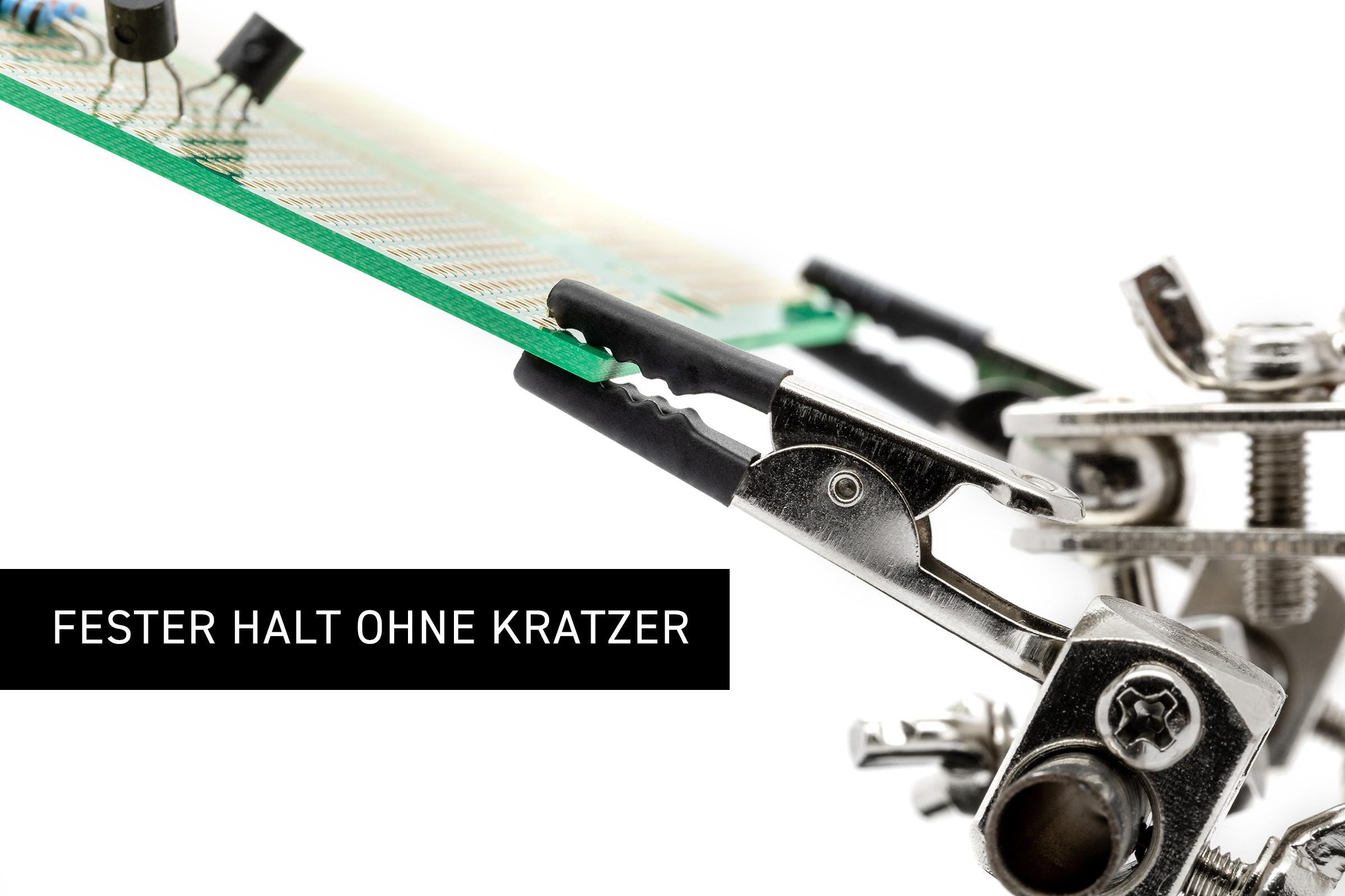 Lötwerkzeug mit einer grünen Leiterplatte, die von zwei schwarzen Klemmen gehalten wird. Text: Fester Halt ohne Kratzer.