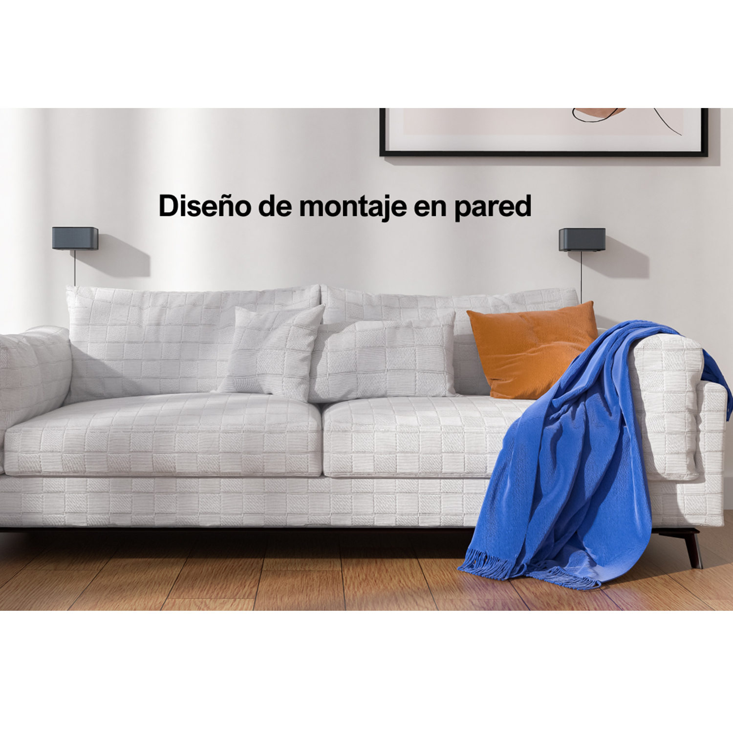 Un sofá blanco con almohadas y una manta azul, una imagen en la pared y dos altavoces.