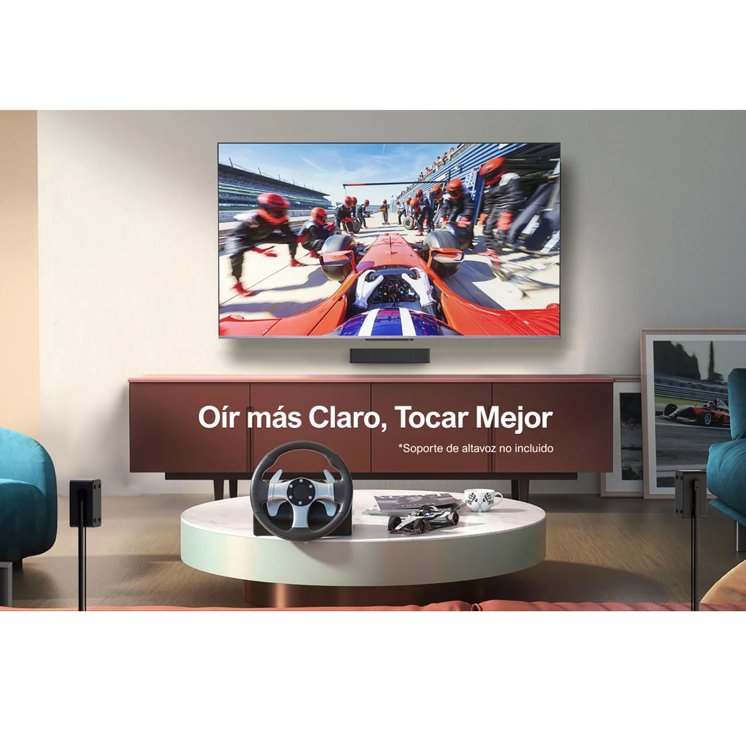Un televisor grande muestra una escena de carreras de coches, con un volante sobre una mesa.