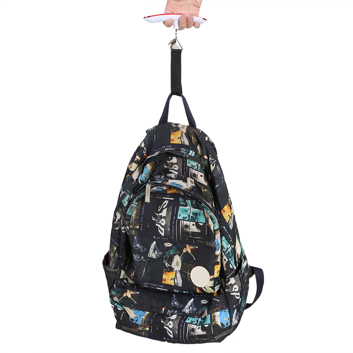 Ein Rucksack wird mit einer kleinen Waage gewogen, die an einem Handgerät hängt.