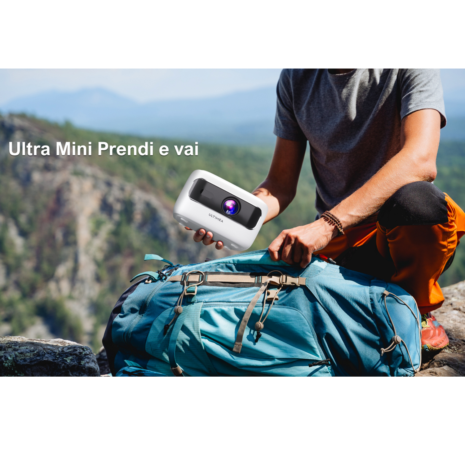 Un uomo tiene un mini proiettore bianco sopra uno zaino, sfondo montano. Testo: Ultra Mini.