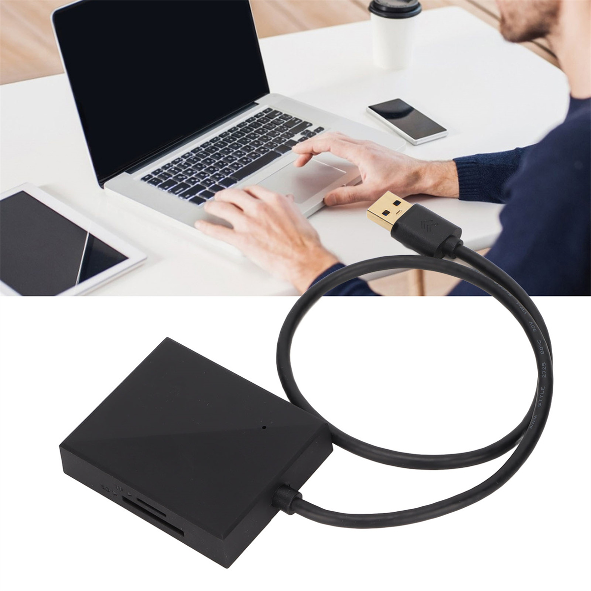Eine Person benutzt einen Laptop. Unterhalb befindet sich ein schwarzer USB-Kartenleser, der über ein USB-Kabel verbunden ist.