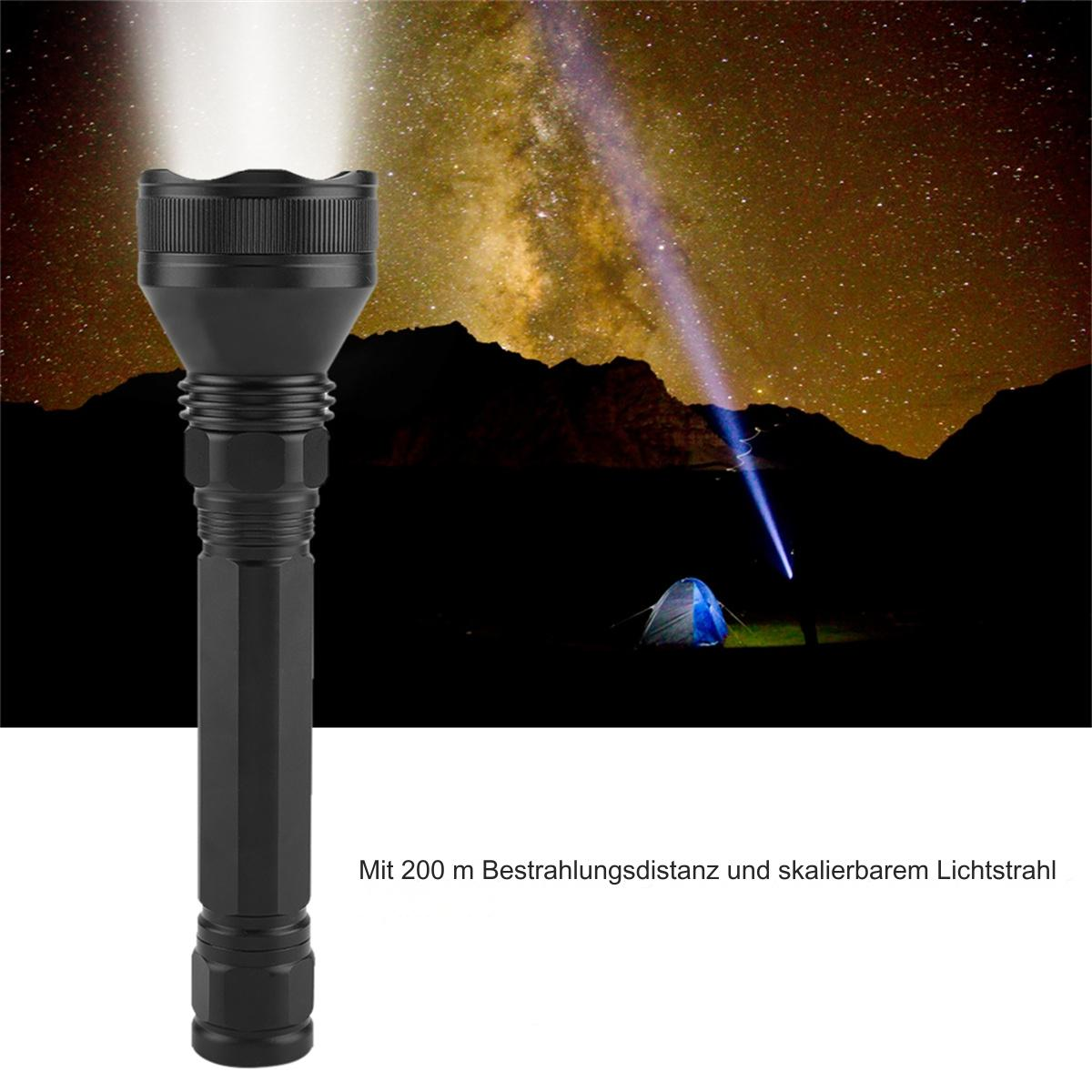 Schwarze Taschenlampe, die Licht in den Nachthimmel strahlt. Ein Zelt im Hintergrund.