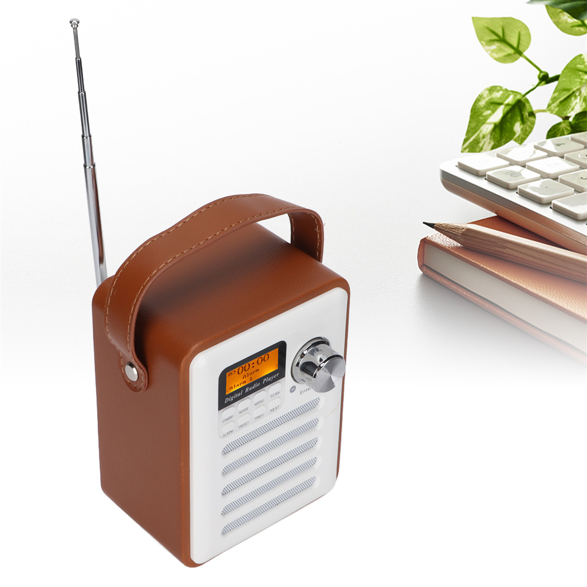 Ein braun-weißes Retro-Radio mit Griff, Notizblock und Bleistift.