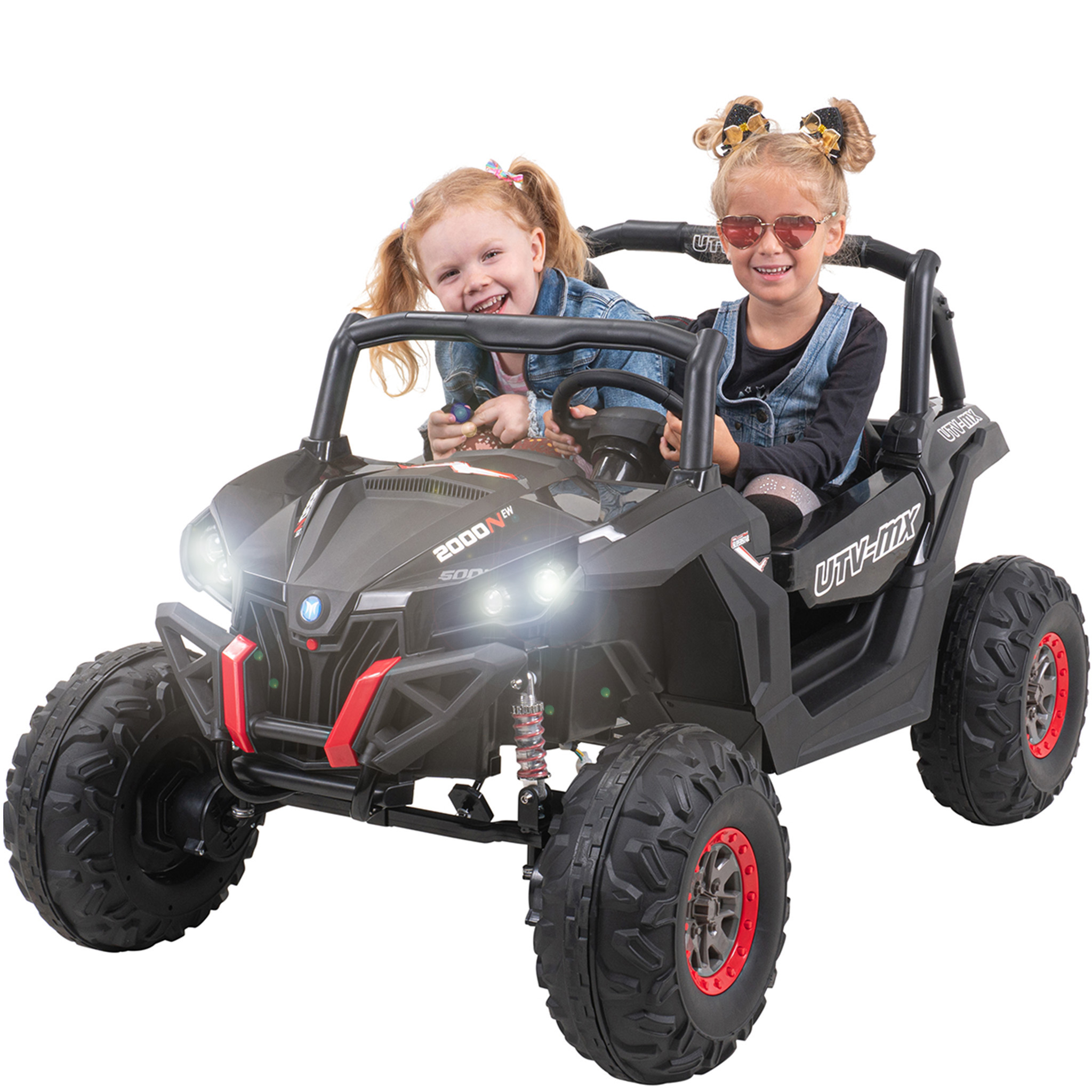 Zwei junge Mädchen in einem schwarz-roten Spielzeugauto. Beide lächeln. Das Auto ist schwarz mit roten Details.