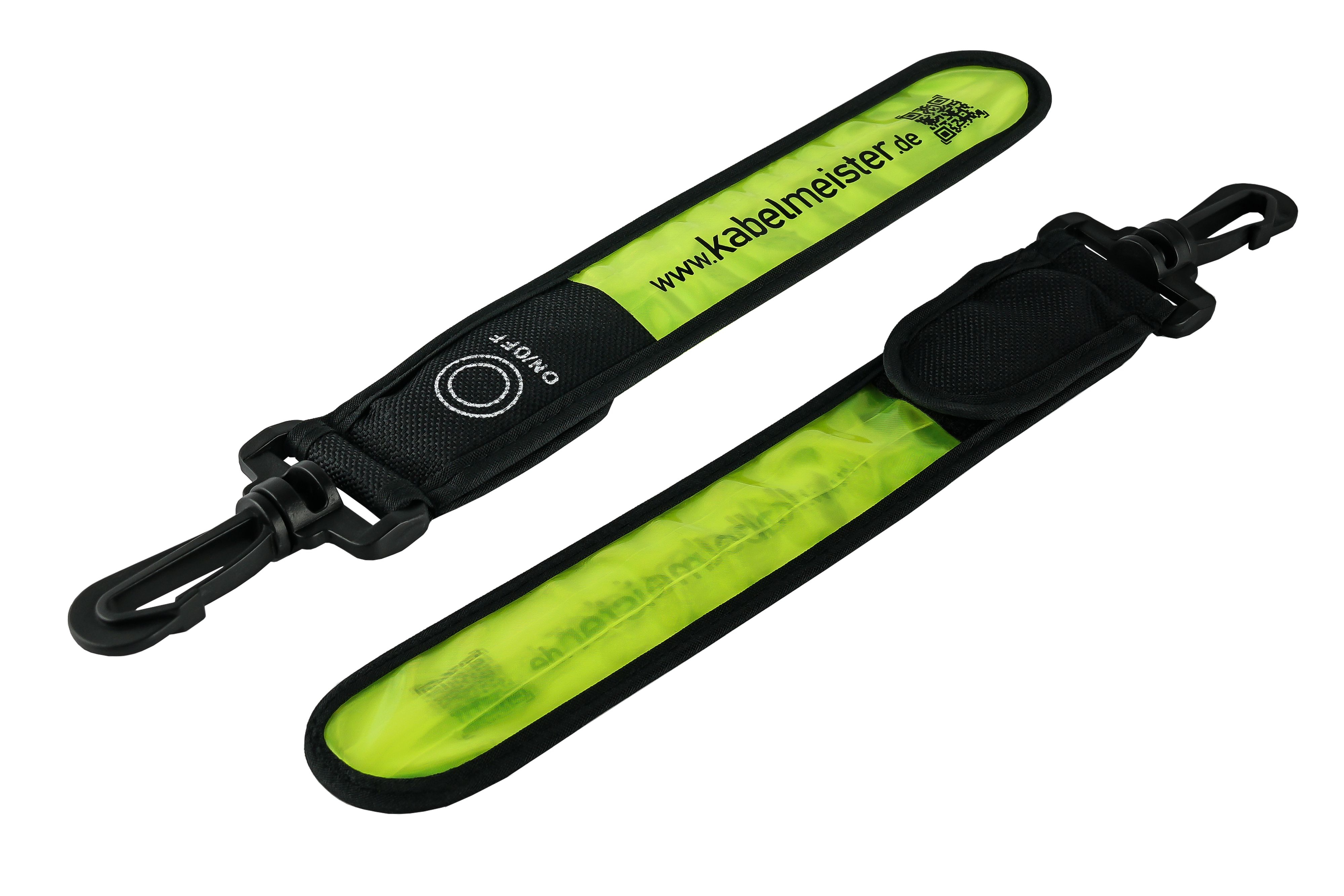 Zwei schwarze, reflektierende Armbänder mit gelbem Lichtstreifen, mit schwarzem Clip und Text 'www.kabelmeister.de'.