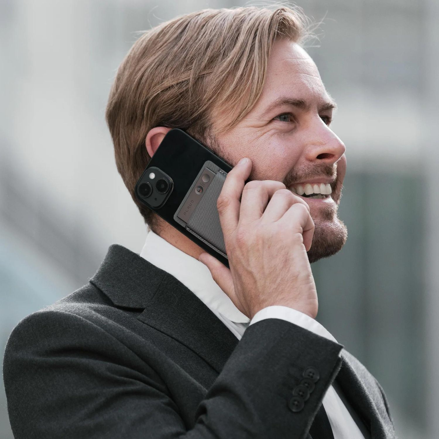 Mężczyzna w garniturze prowadzi rozmowę telefoniczną z etui na telefonie.