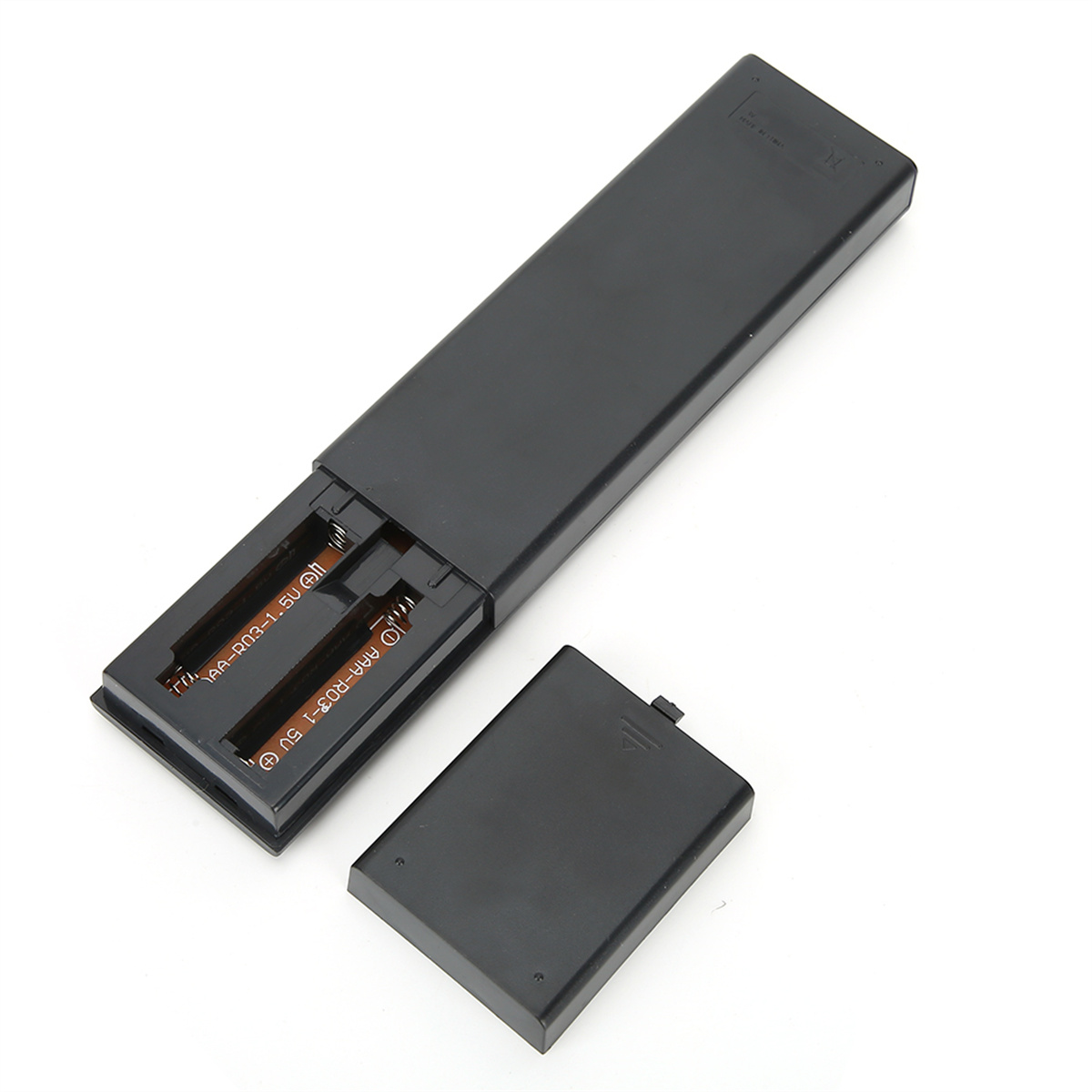 Eine schwarze Fernbedienung mit geöffnetem Batteriefach, das zwei AA-Batterien zeigt.