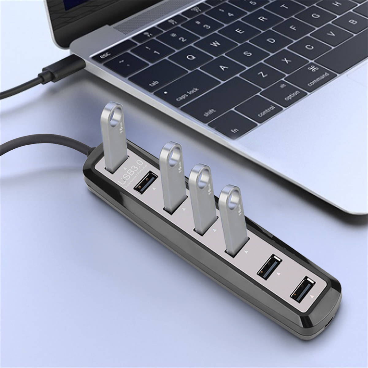 USB-Hub mit vier USB-Anschlüssen und vier USB-Sticks an einem Laptop.