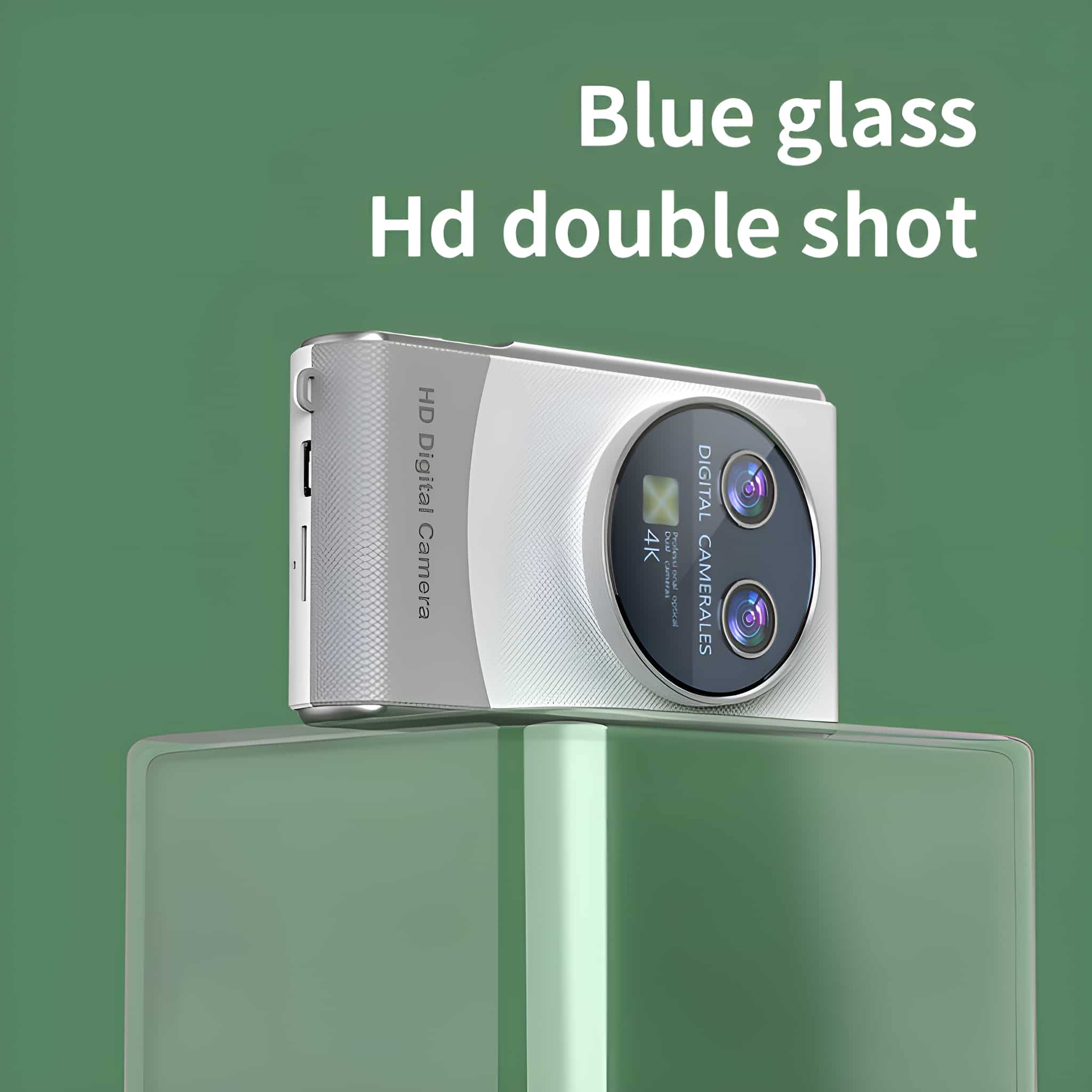 Eine weiße Kamera mit zwei Objektiven steht auf einem grünen Glasständer, grüner Hintergrund.