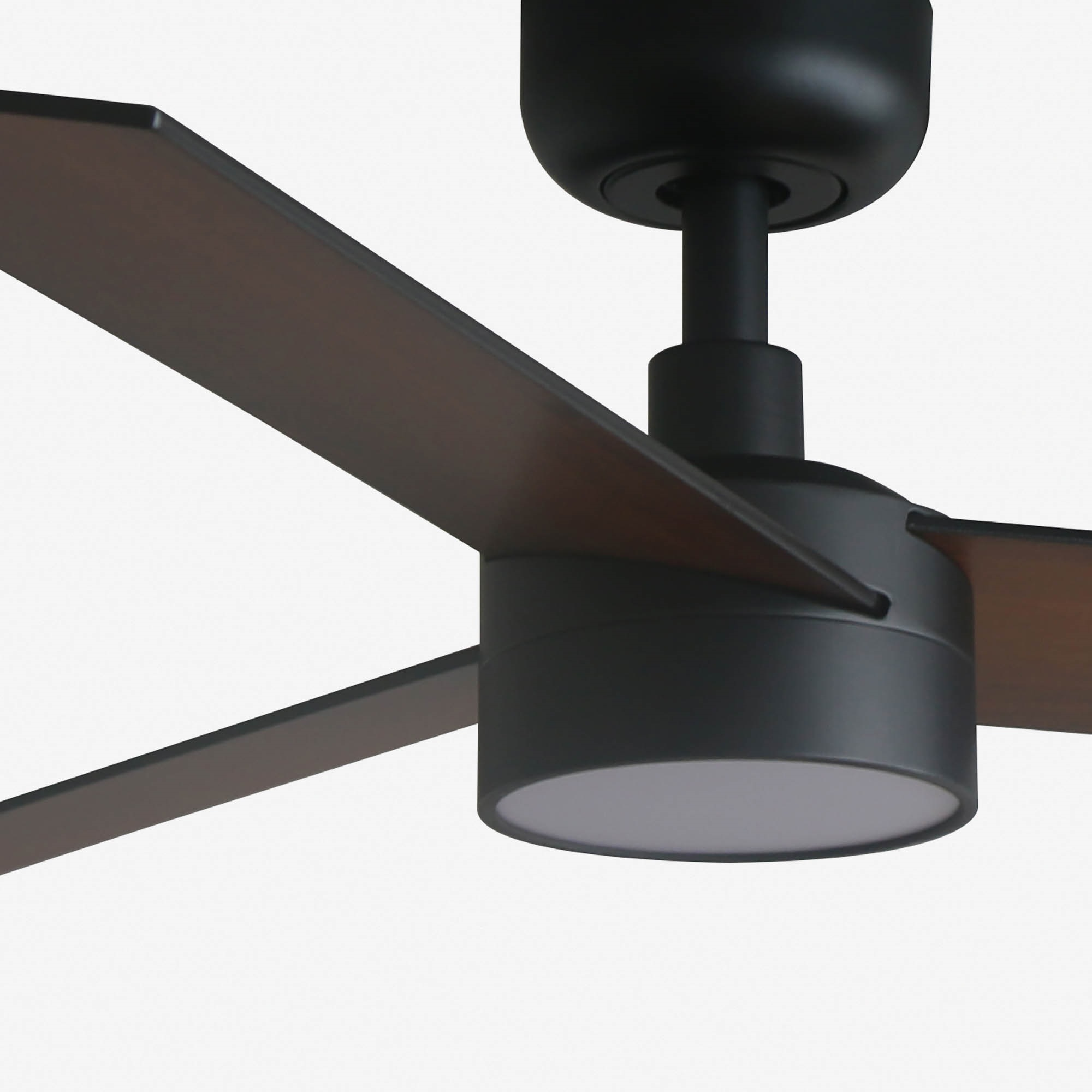 Un ventilatore da soffitto nero con pale marroni scure e un apparecchio di illuminazione bianco.