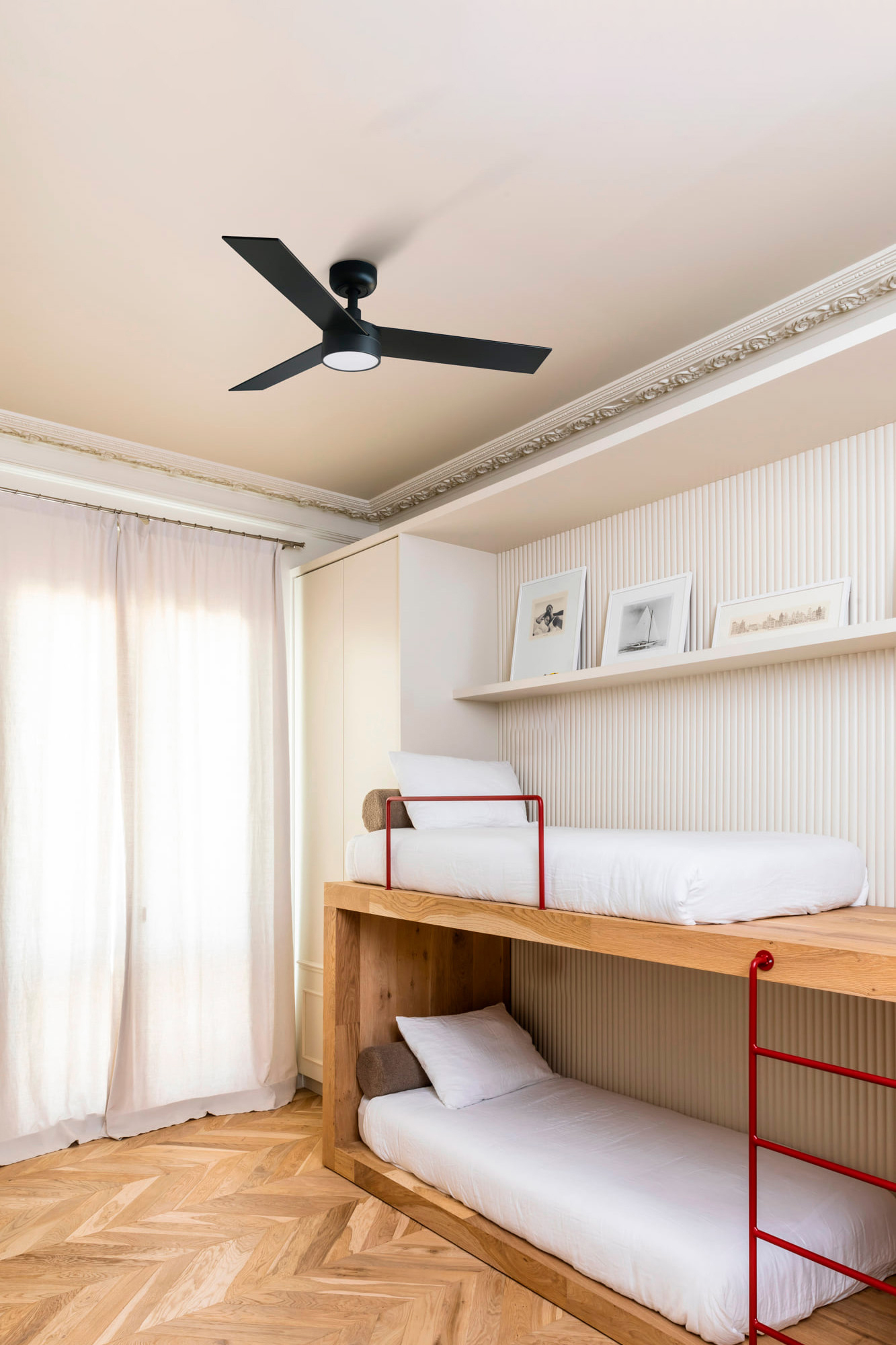 Schlafzimmer mit Etagenbetten und Deckenventilator, mit Holzböden und neutralen Farben.