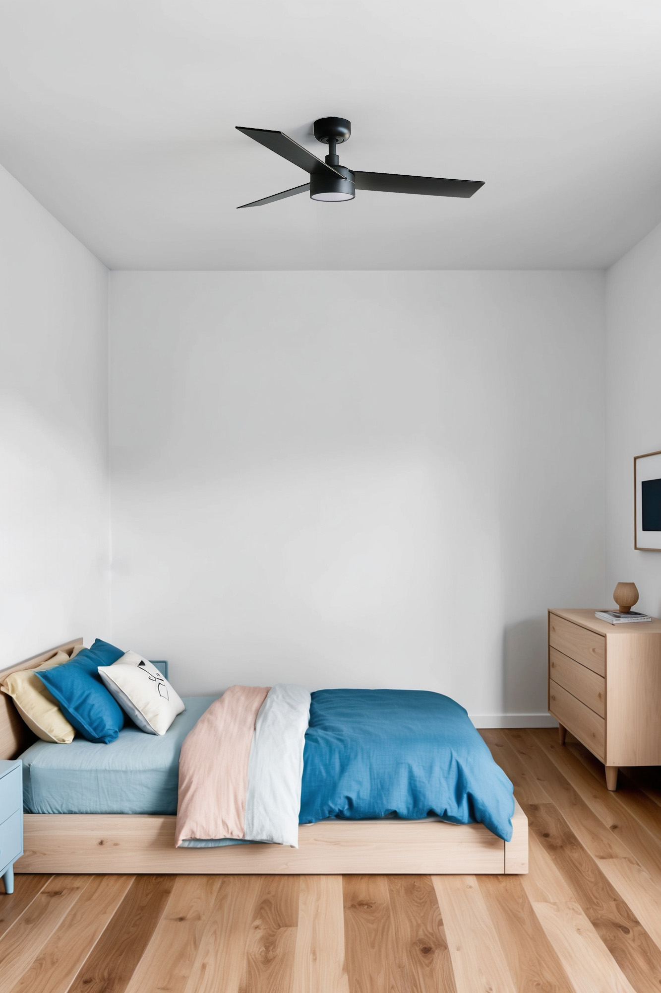 Schlafzimmer mit Bett, blauen und rosa Laken, Holzboden und Deckenventilator. Weiße Wände.