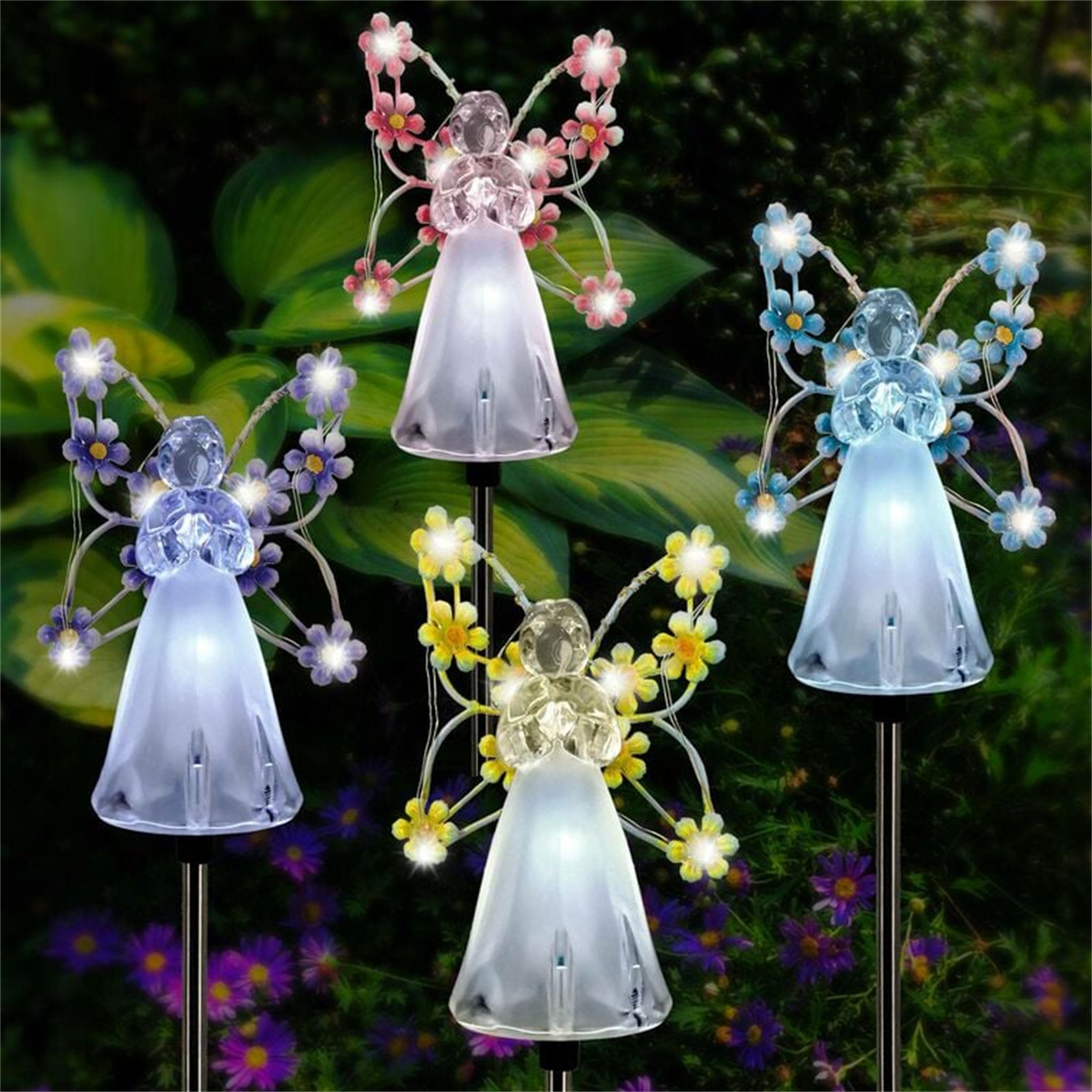 Vier Feengartenlichter mit farbenfrohen Blumenflügeln in einem Garten.