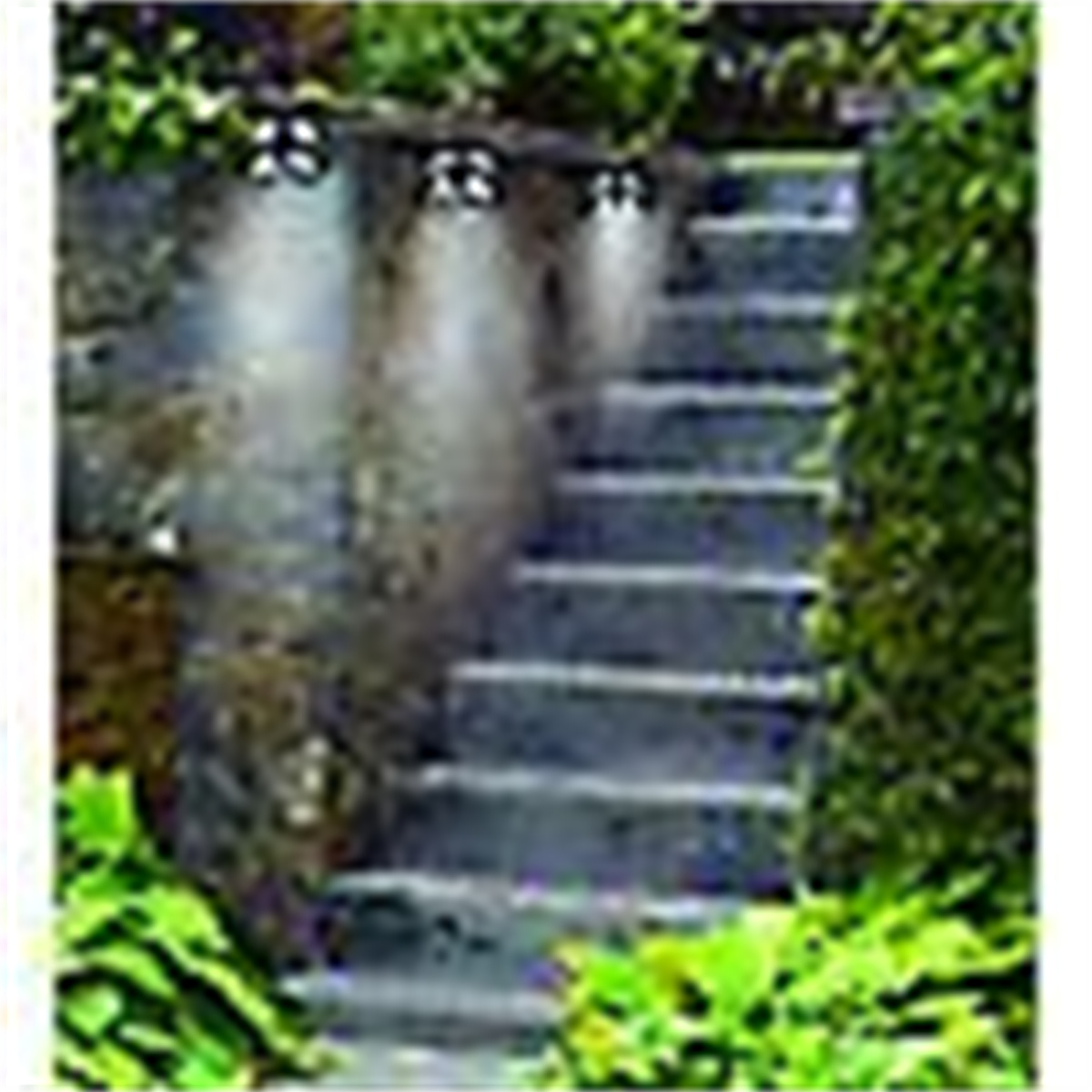 Treppe mit Lichtern, die darauf scheinen. Die Lichter sind an einer Steinmauer links befestigt.