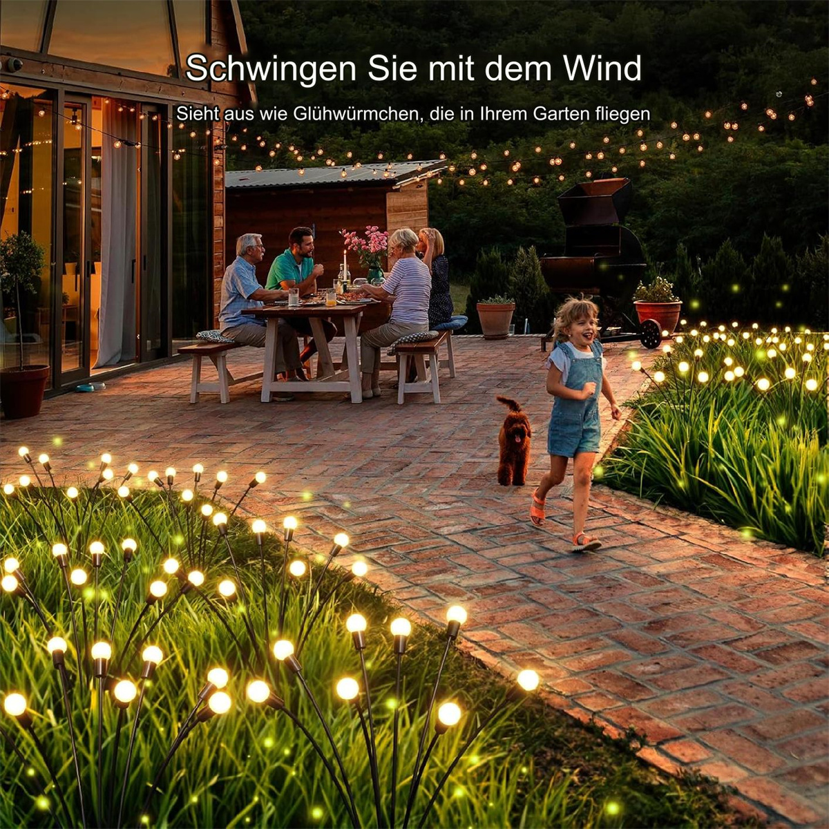 Menschen essen im Hinterhof an einem Tisch, mit Lichterketten und einem kleinen Mädchen, das rennt.