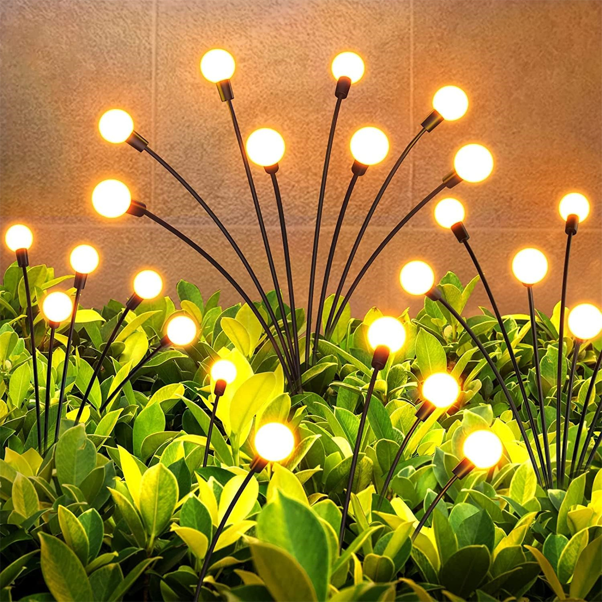 Eine Gruppe von Außenleuchten in einem Beet mit grünen Pflanzen. Die Lichter sind rund und leuchten.