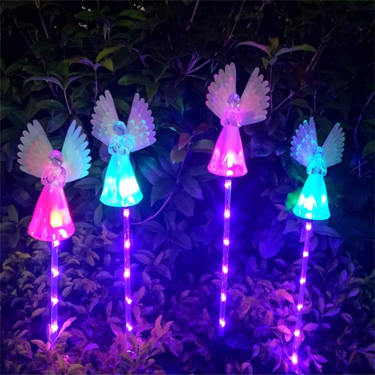 Vier Engel-Gartenlichter, rosa und blau, mit leuchtenden Flügeln, auf einem lila beleuchteten Hintergrund.