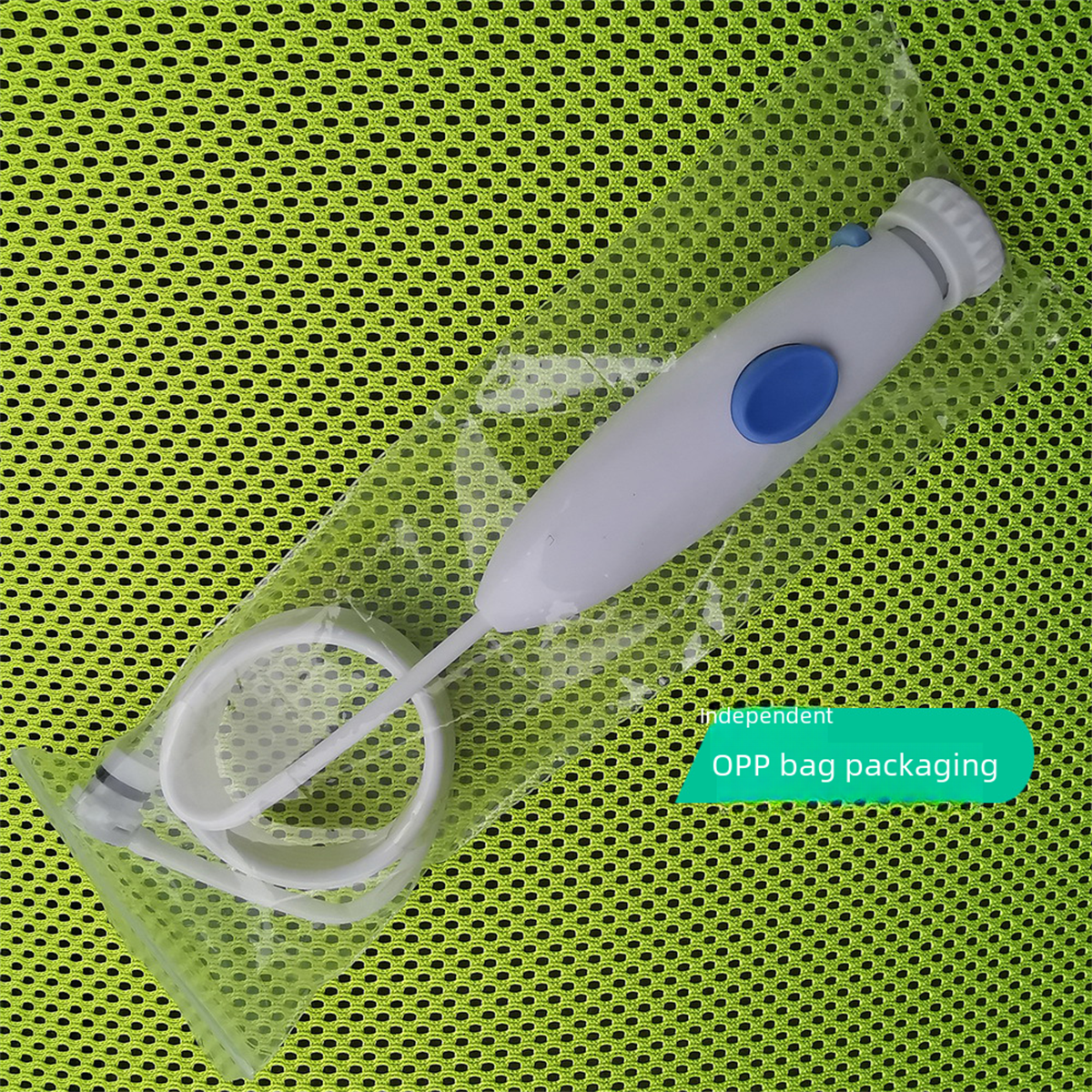 Ein weiß-blaues Mund-Irrigator in Klarsichtverpackung, vor einem gelb-grünen Mesh-Hintergrund.