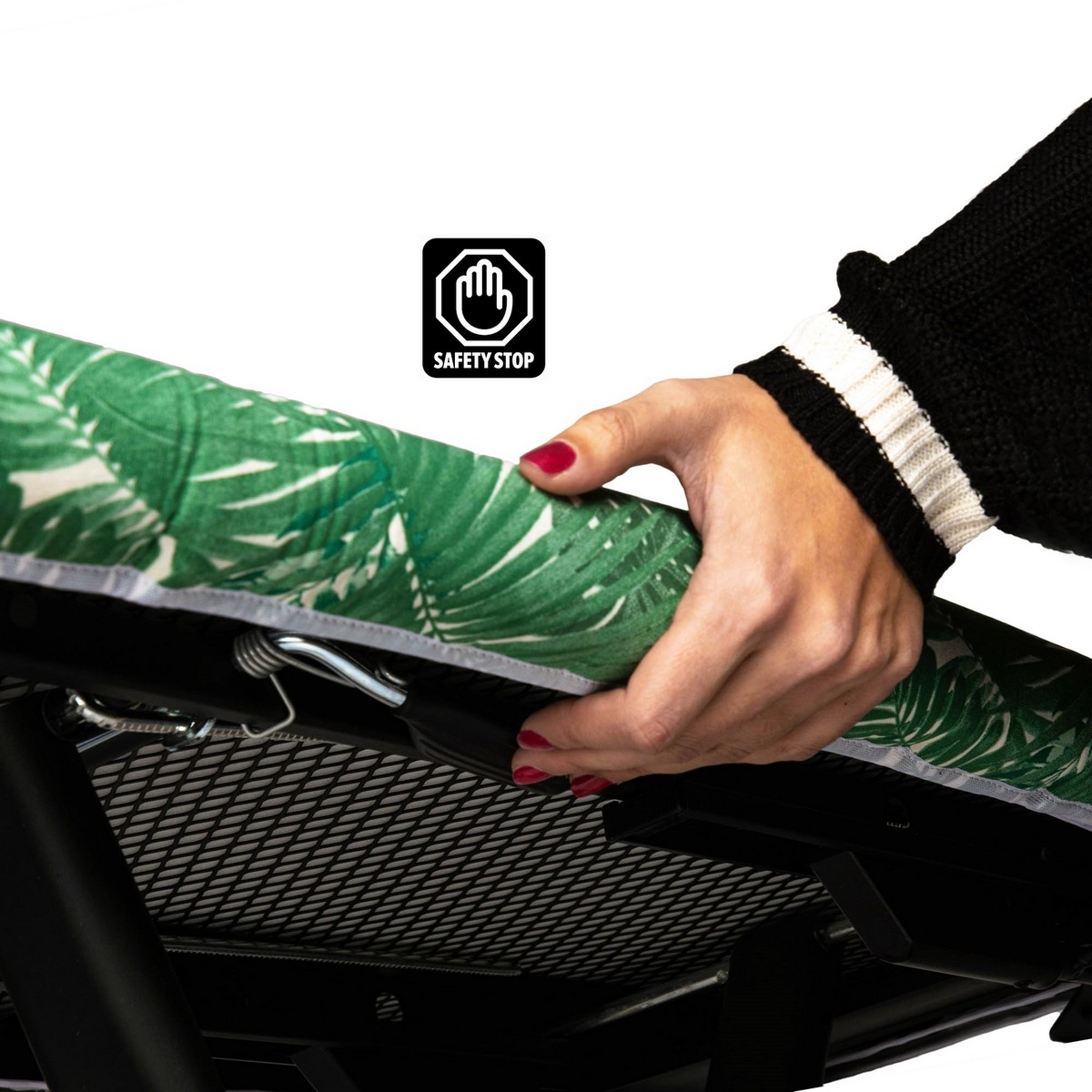 Una mano sostiene una funda verde y blanca para tabla de planchar. El texto Safety Stop es visible.