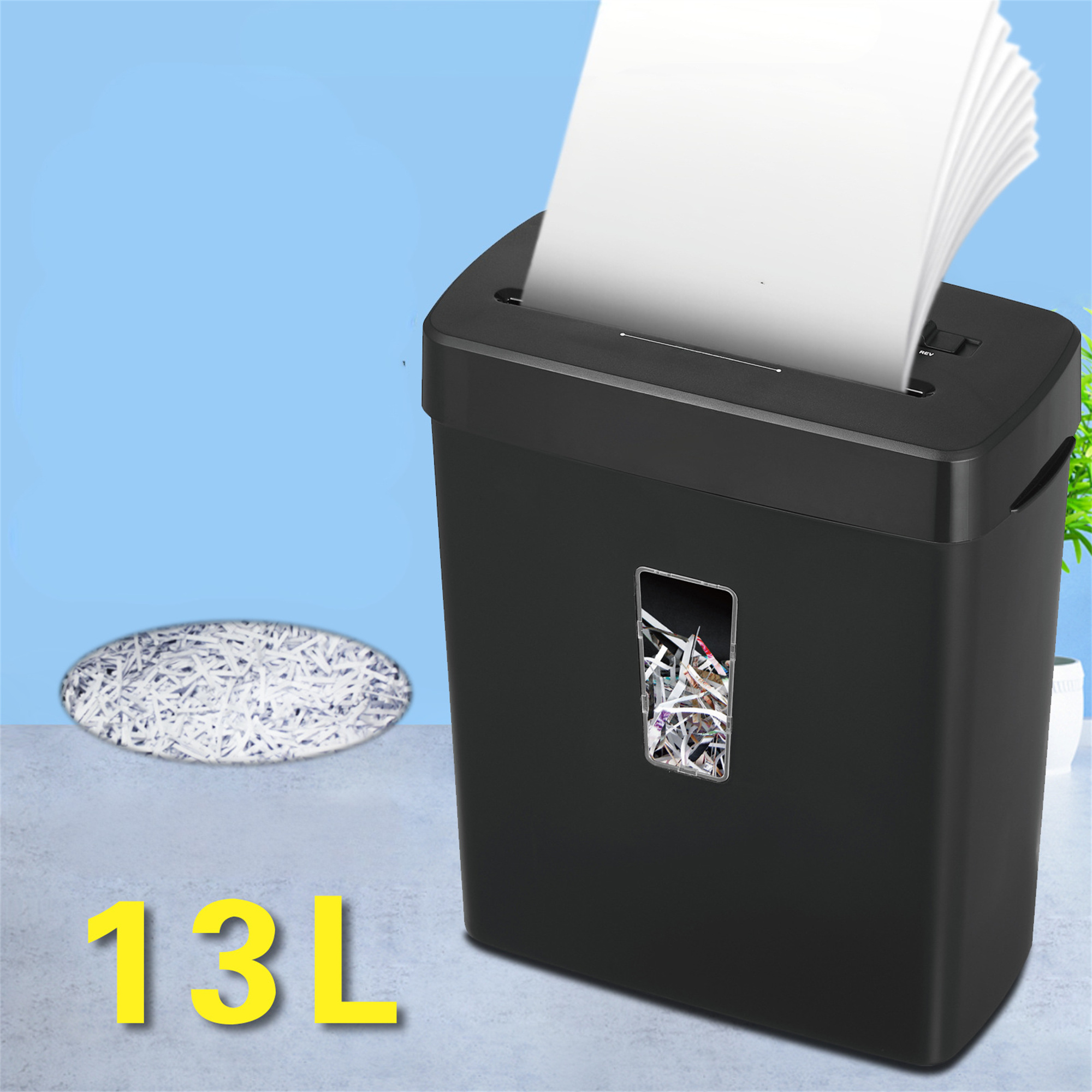 Ein schwarzer Aktenvernichter mit eingelegtem Papier, geschreddertem Papier auf dem Boden.