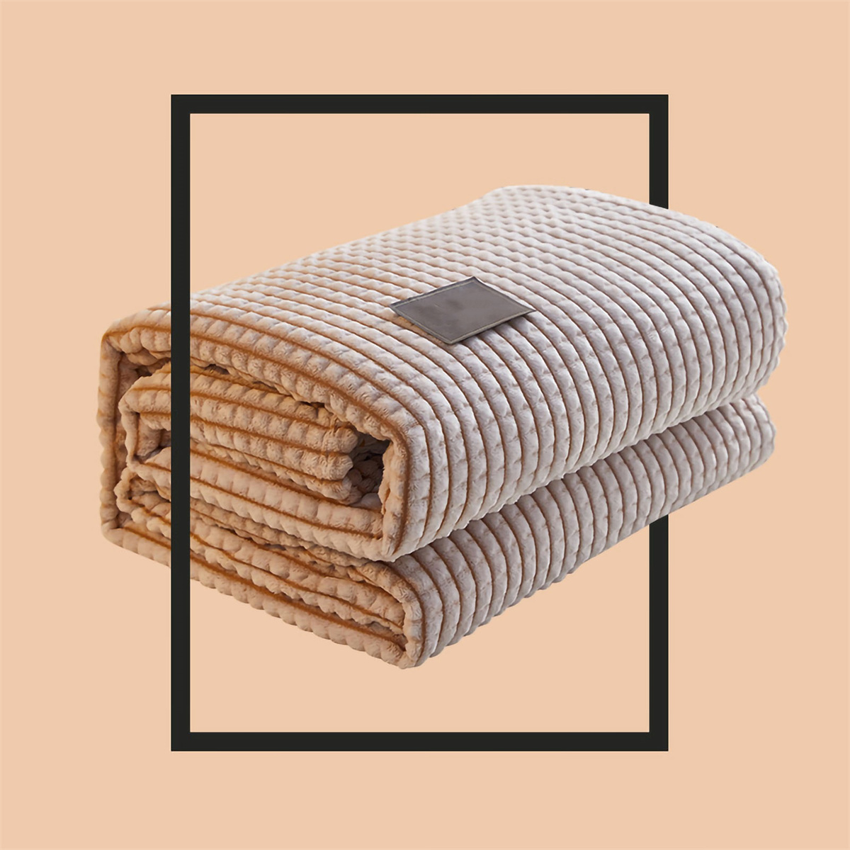 Gefaltete beige Decke mit schwarzem Rahmen, zeigt Textur.