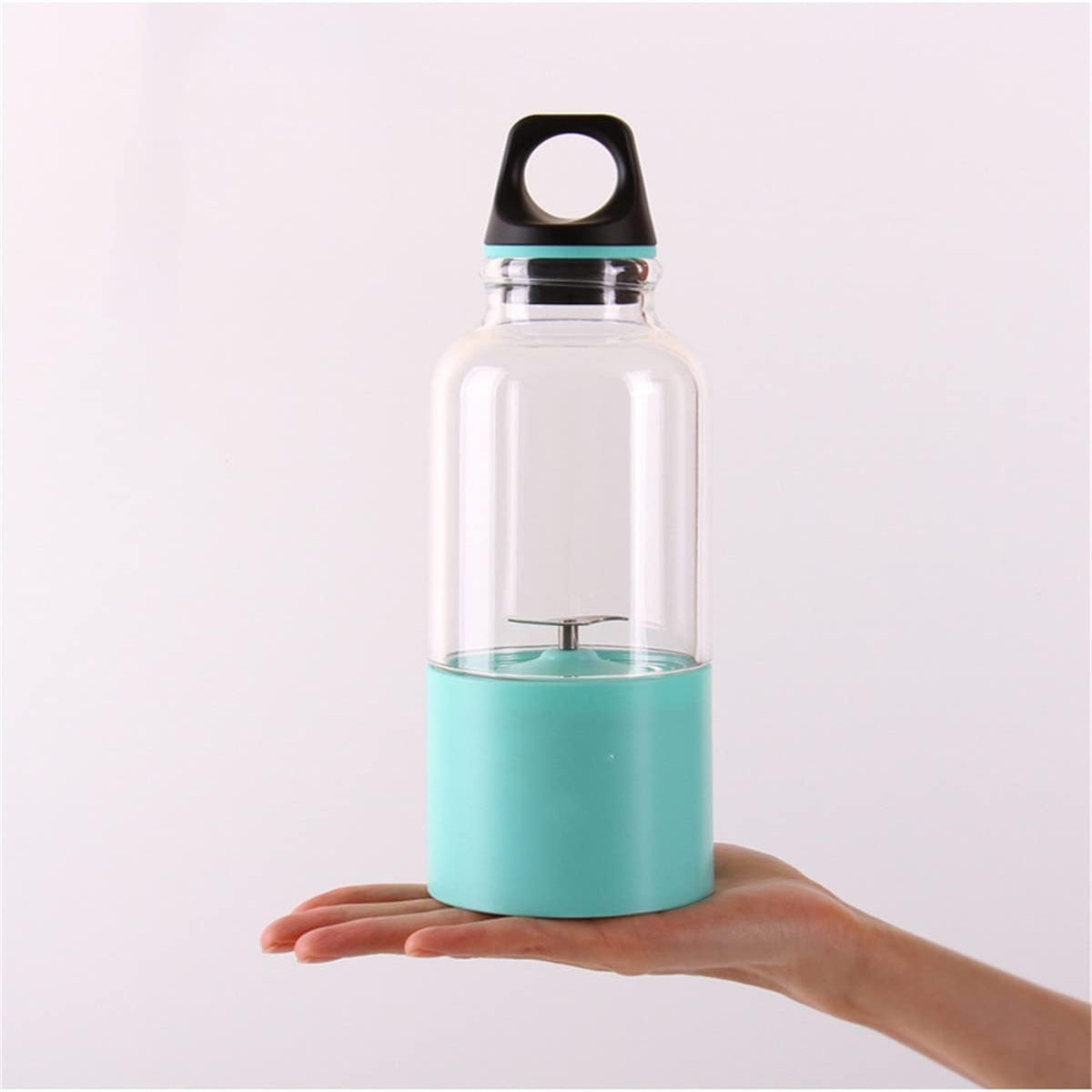 Eine klare, türkisfarbene Mixerflasche mit schwarzem Deckel, gehalten von einer Hand.