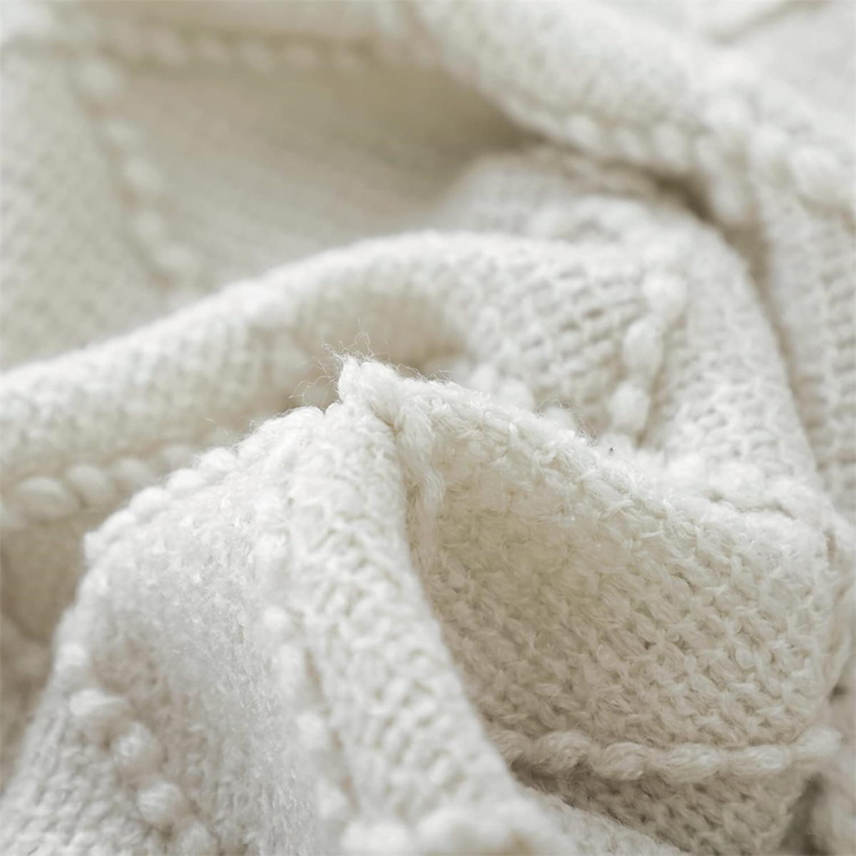 Nahaufnahme von weißem Strickstoff. Textur zeigt gewebtes Muster. Weiches und flauschiges Material.