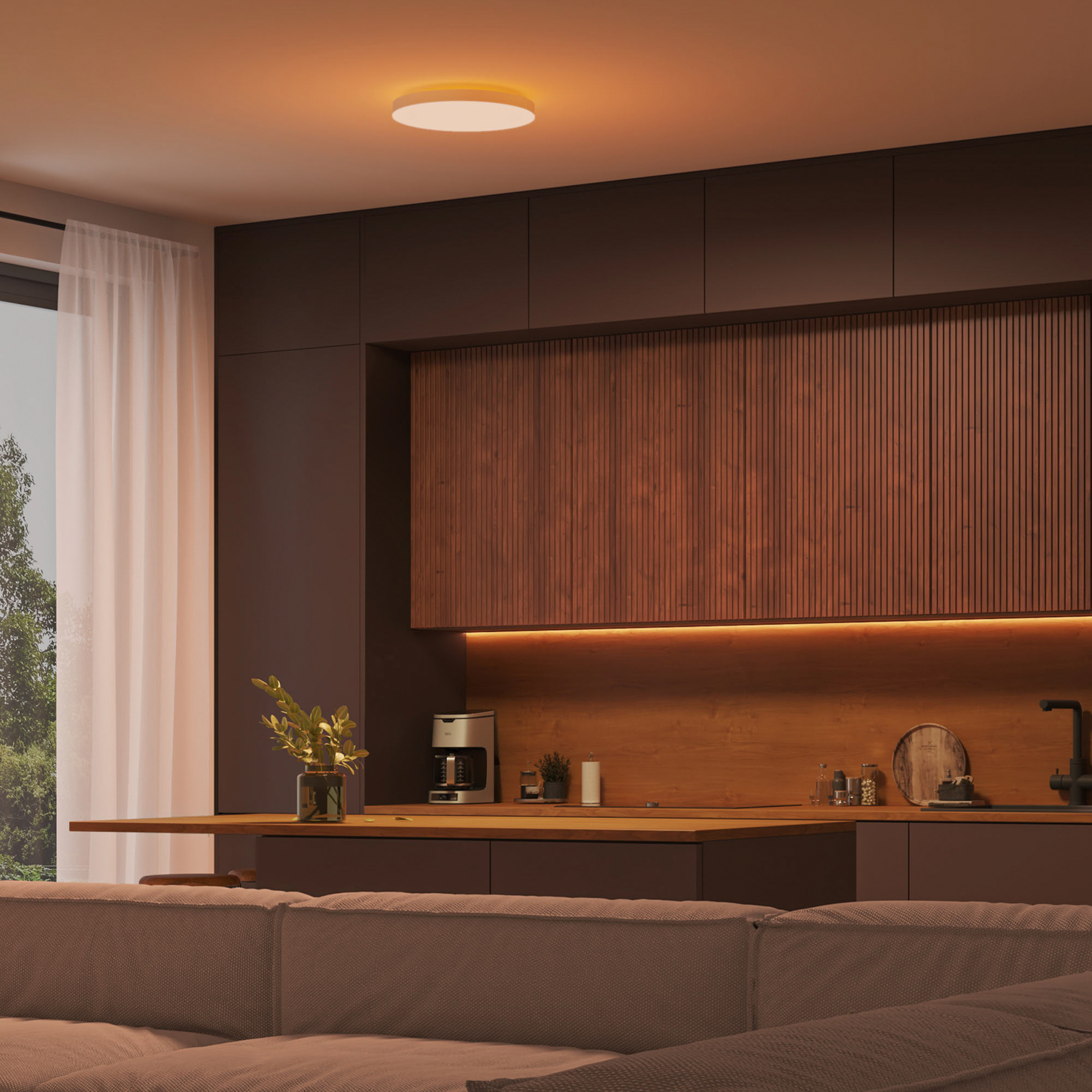 Wnętrze kuchni ze światłem na suficie i sofą.