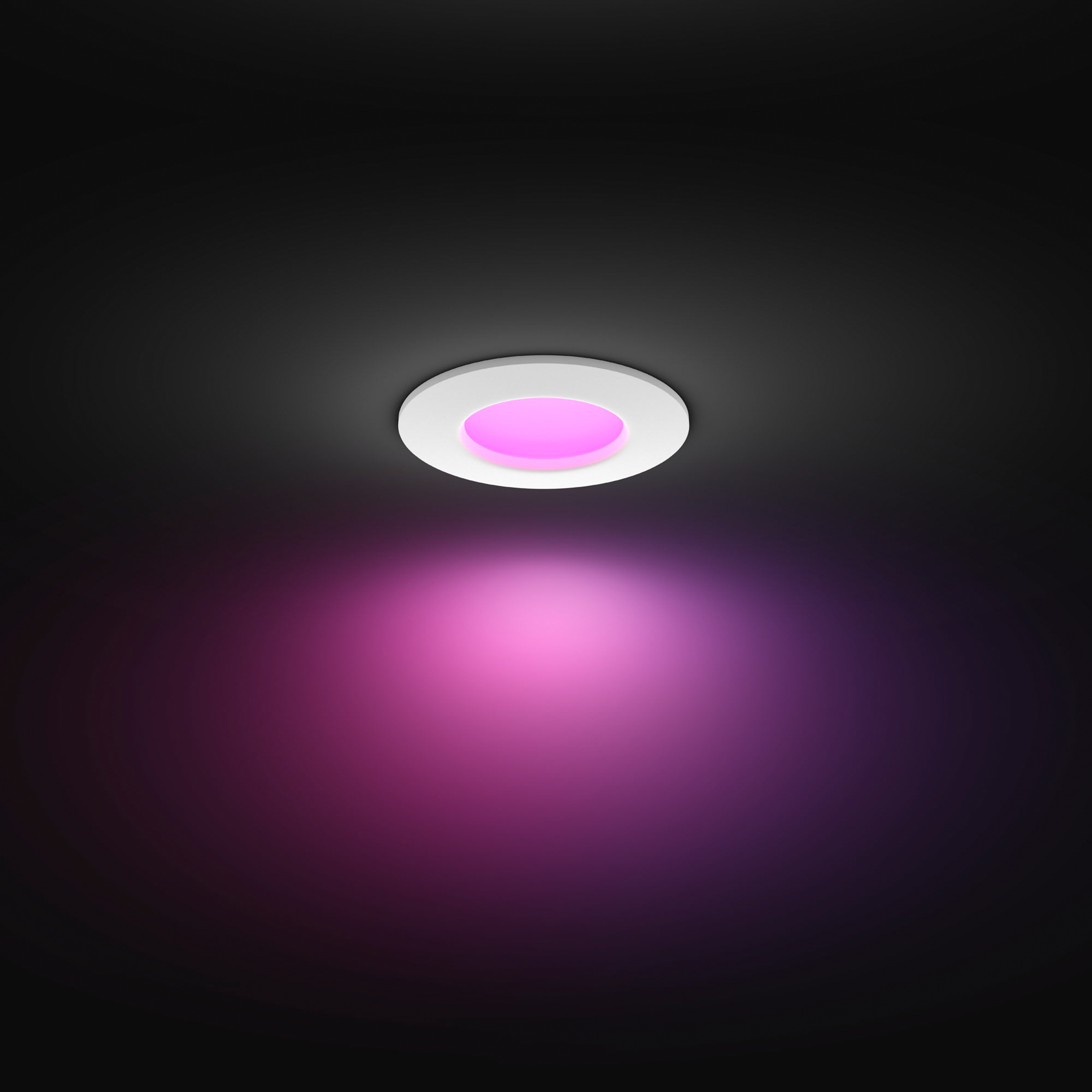 Eine Deckenleuchte, die rosa Licht ausstrahlt. Der Hintergrund ist dunkel.