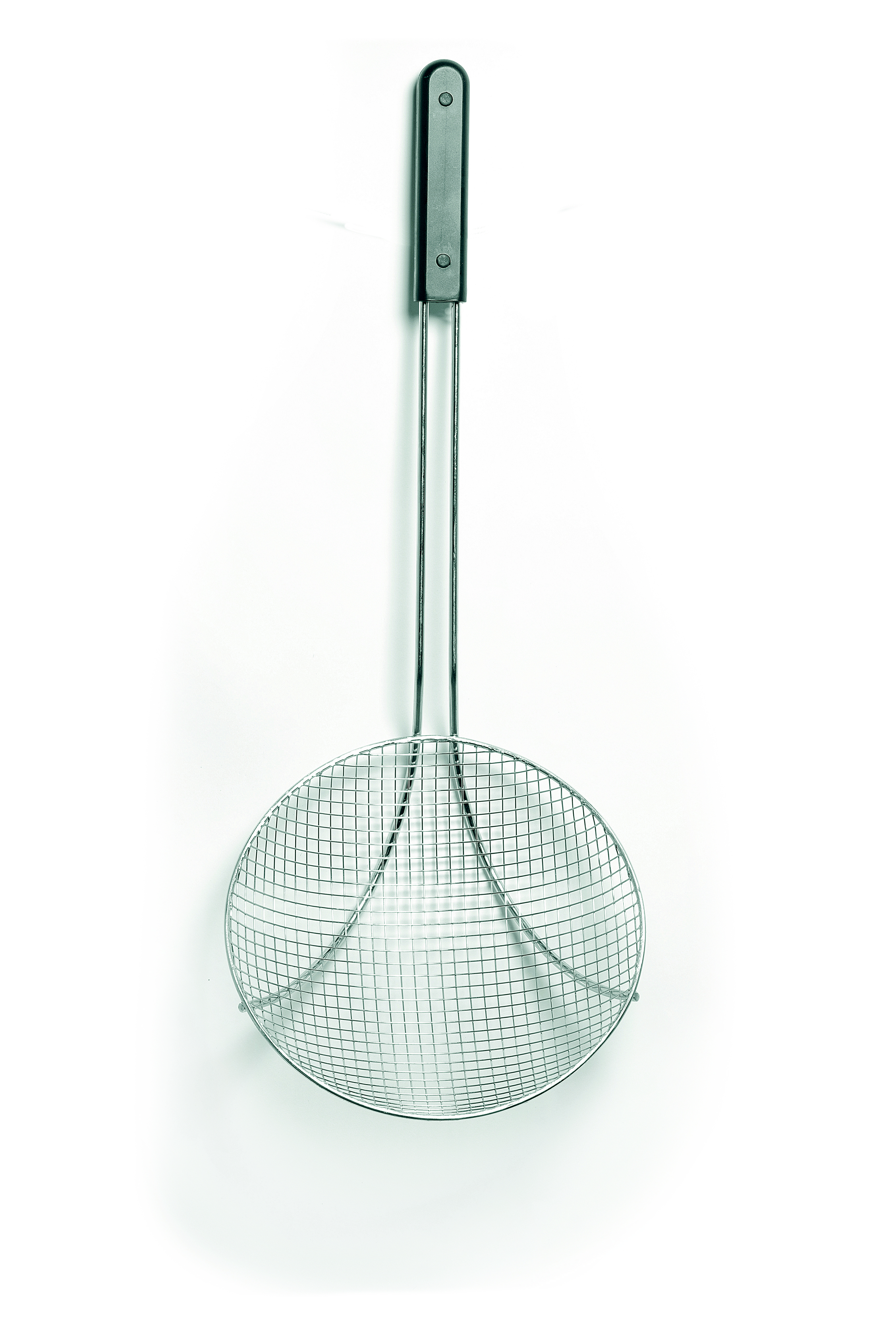Una schiumarola rotonda in metallo con un lungo manico, appesa a una parete bianca.