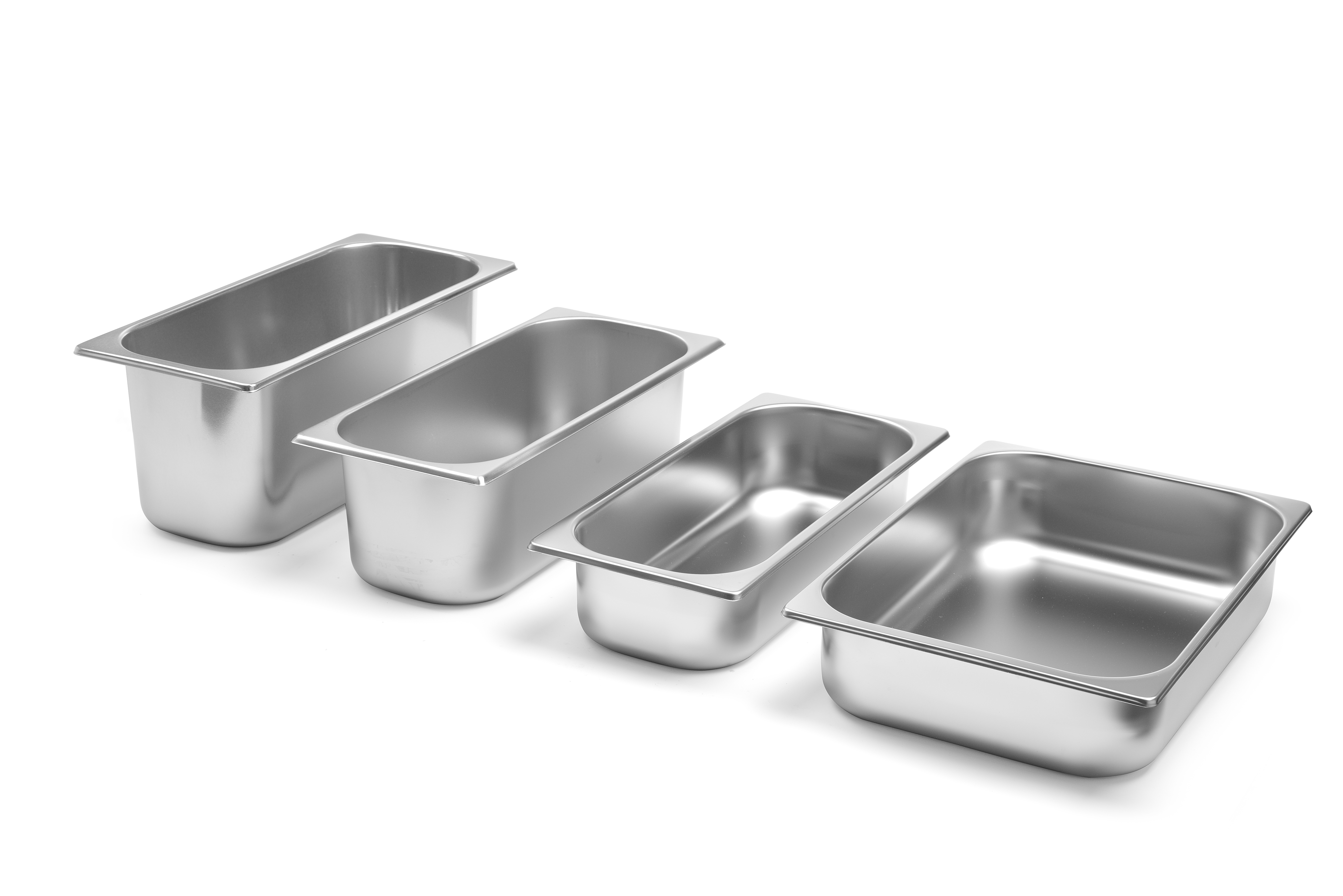 Quattro teglie in acciaio inox di diverse dimensioni su sfondo bianco.