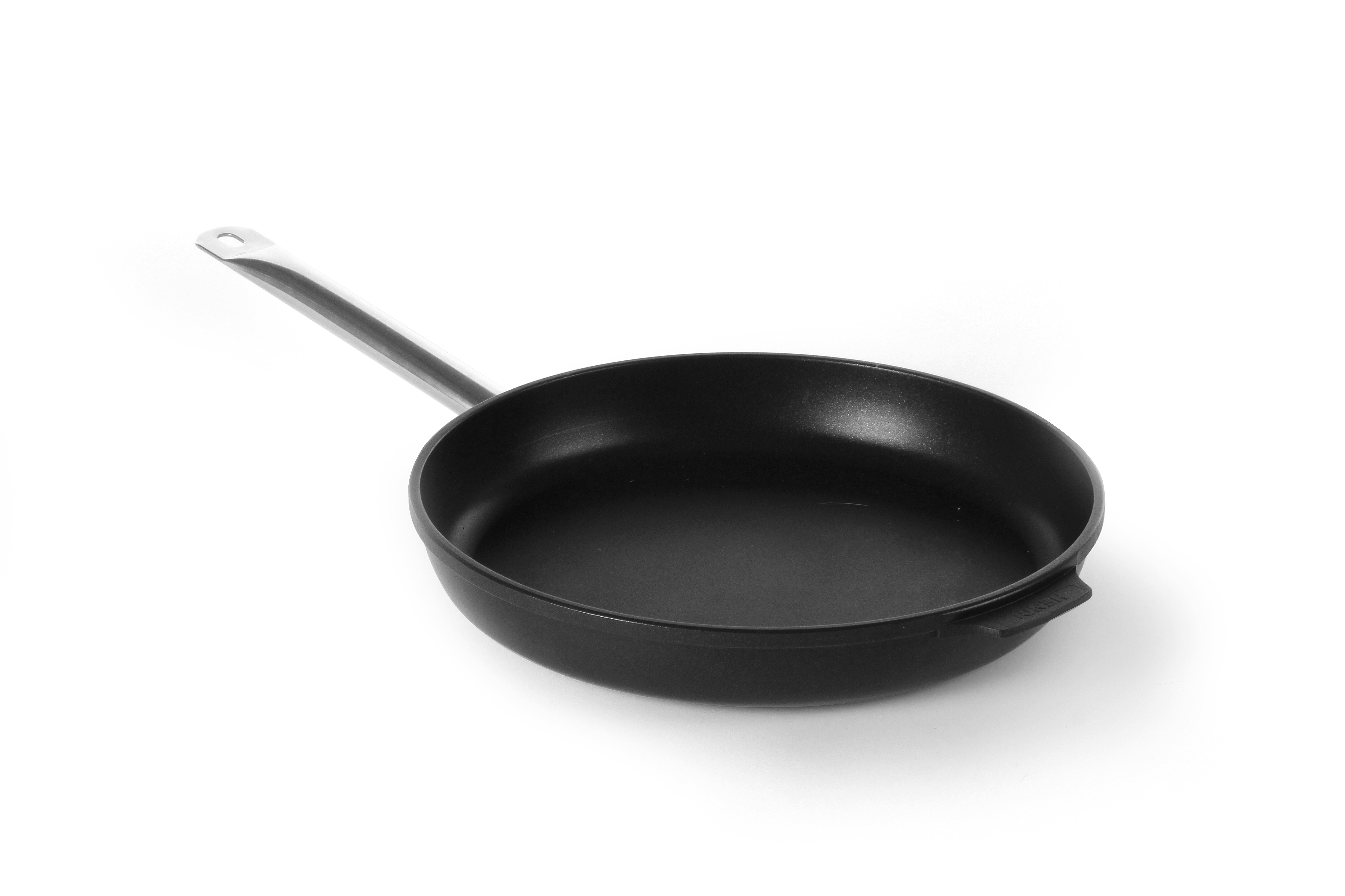 Una padella nera con un lungo manico su sfondo bianco. È vuota e leggermente inclinata.