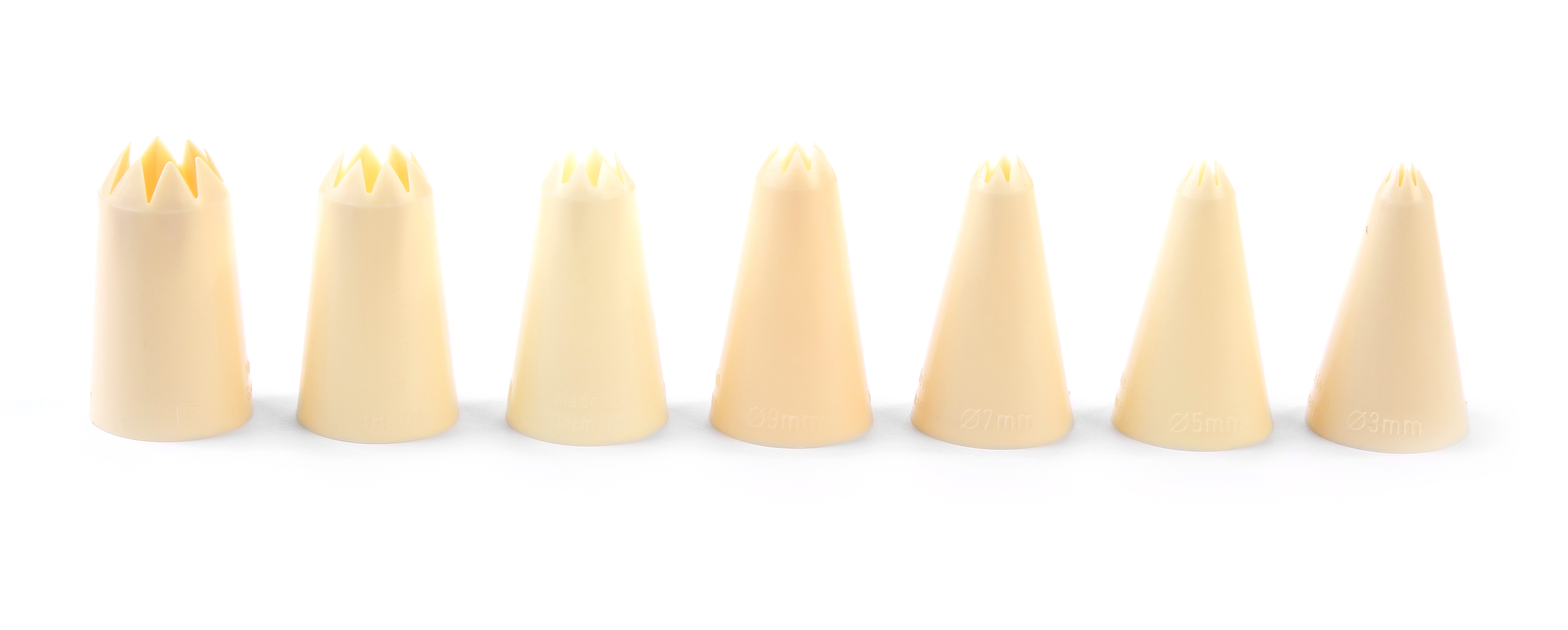 Set di beccucci per pasticceria beige su sfondo bianco. Ogni beccuccio ha una forma a stella diversa.