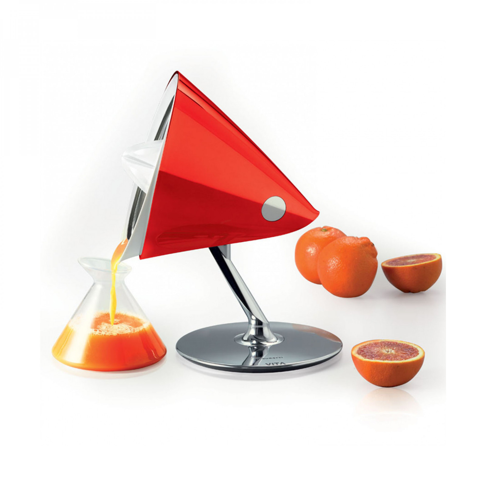 Uno spremiagrumi rosso versa succo d'arancia in un bicchiere. Arance a destra.