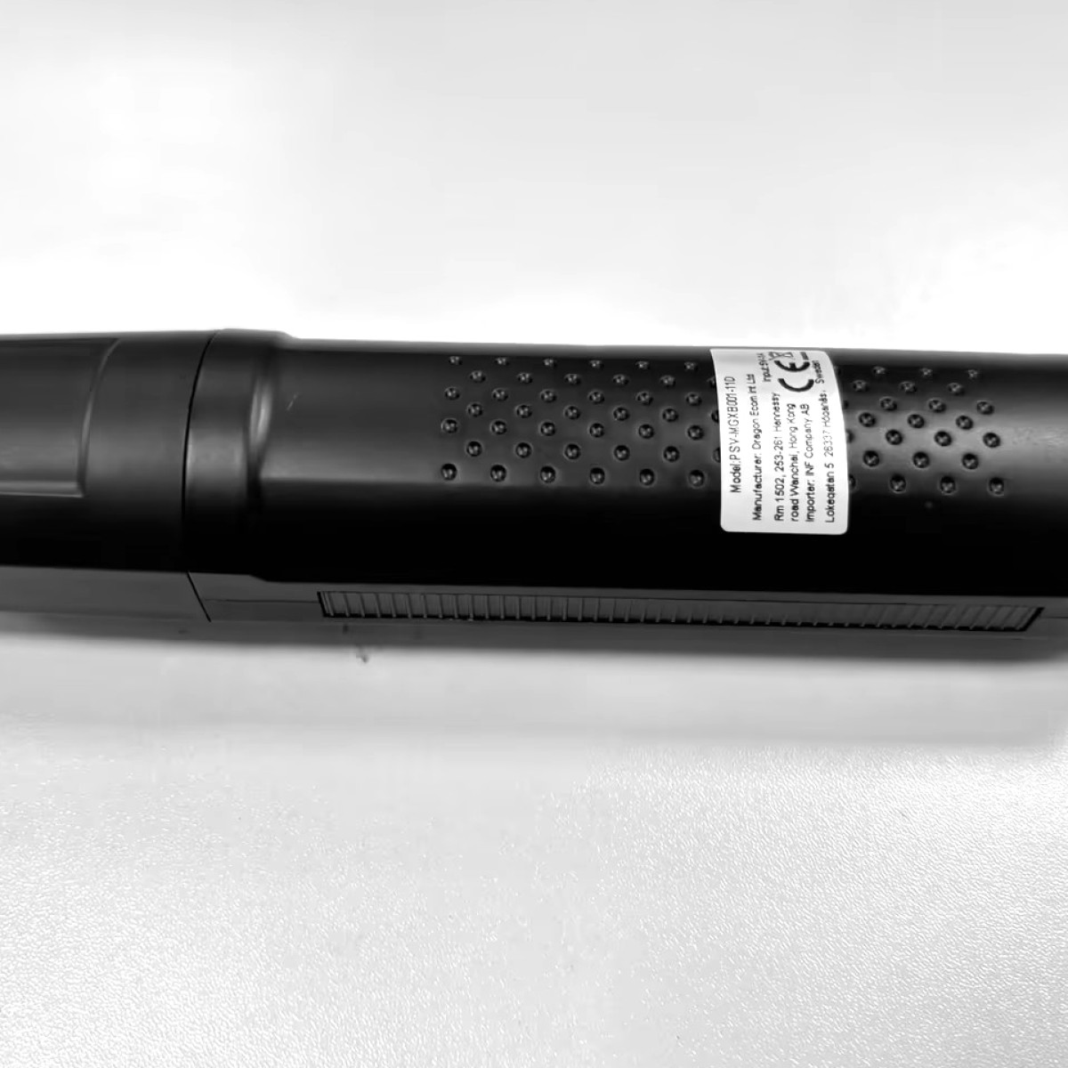 Czarne urządzenie z oznaczeniami i etykietami, widok z bliska.