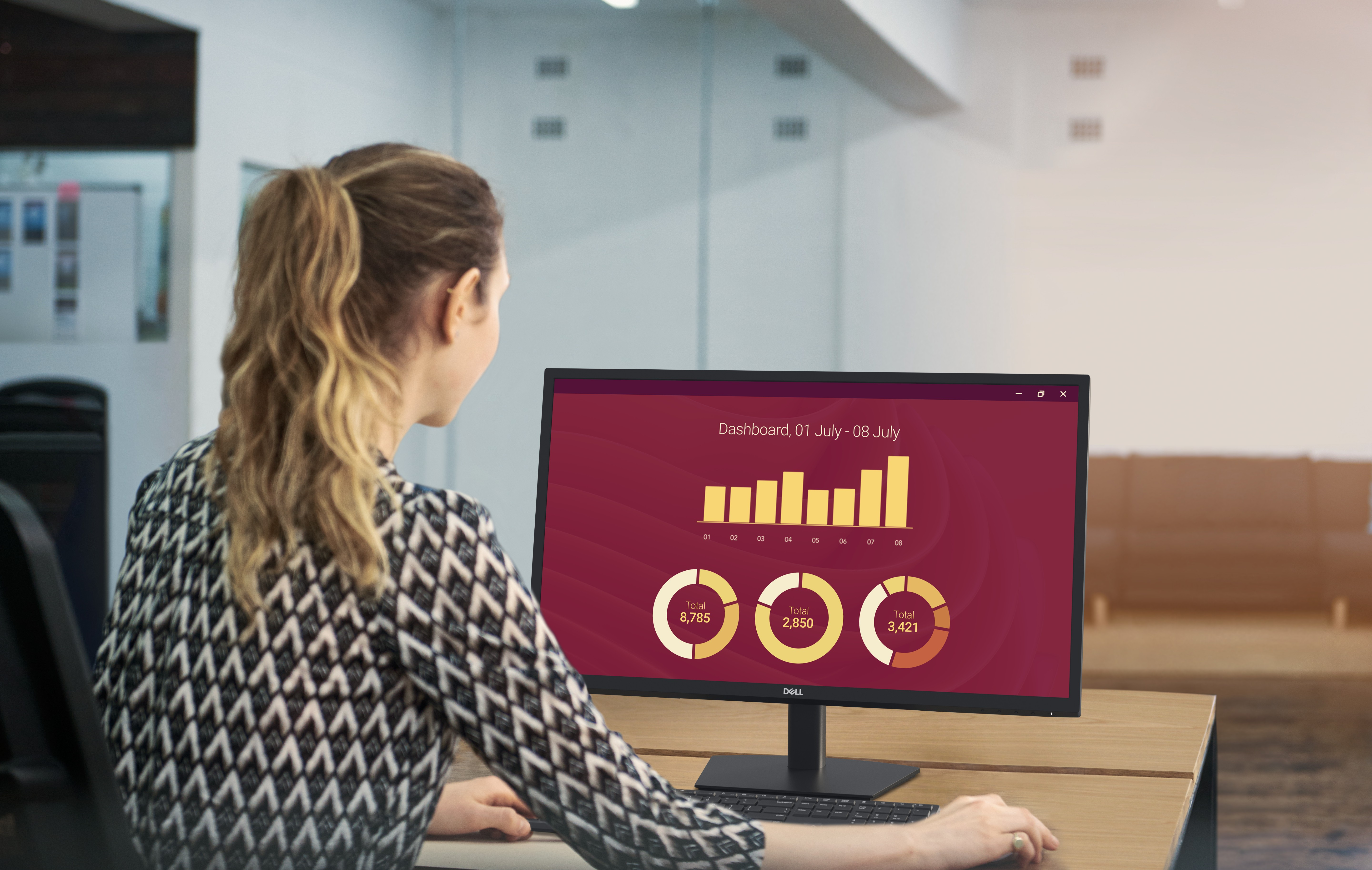 Femme travaillant sur ordinateur avec graphiques de données.