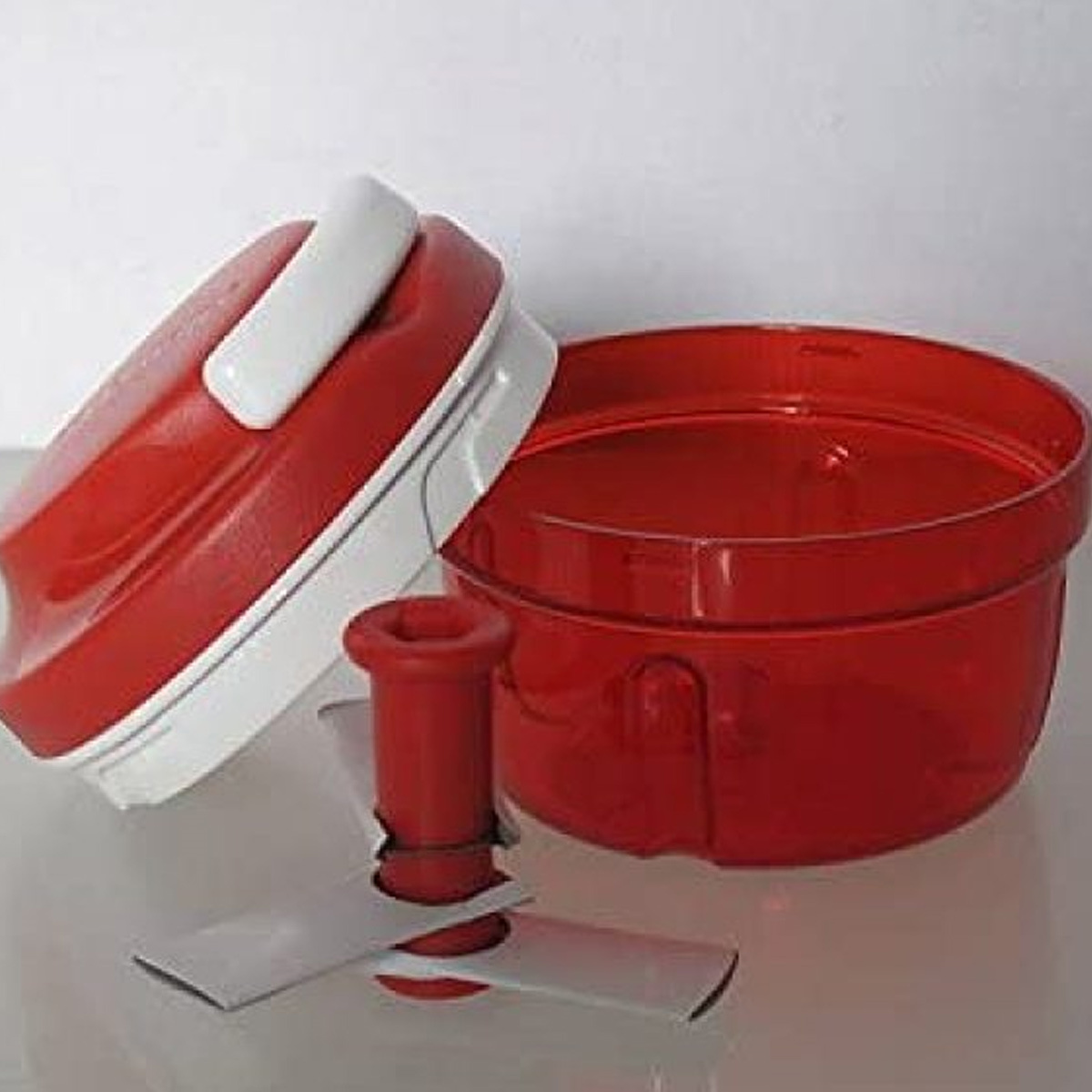 Ein roter und weißer Zerkleinerer mit rotem Behälter, Deckel und Klingen.
