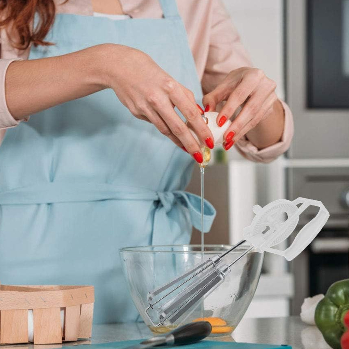 Frau, die ein Ei mit einem Handmixer in eine Schüssel schlägt. Zutaten und Gemüse sichtbar.