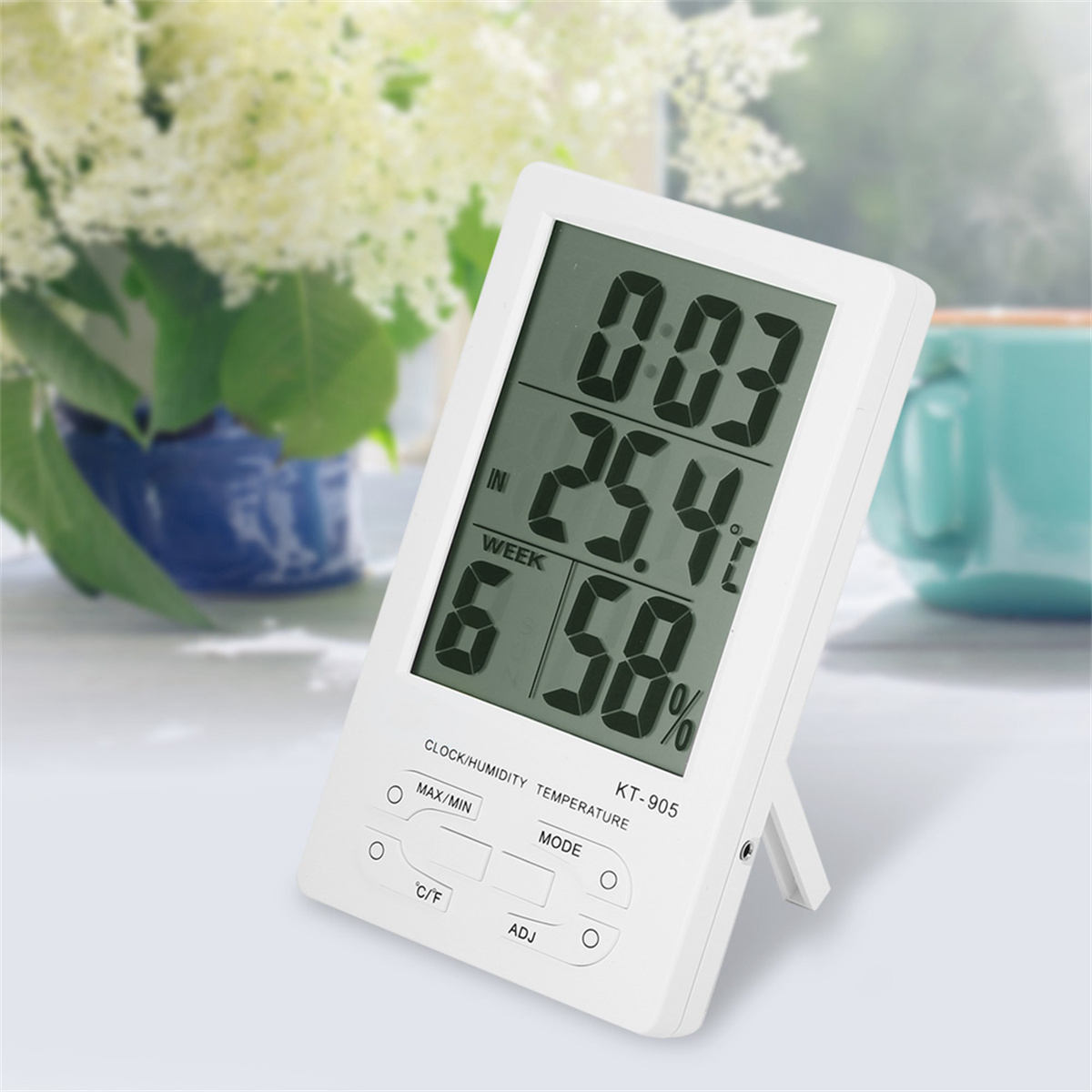 Eine weiße digitale Uhr/Feuchtigkeit/Temperaturanzeige, die Zeit, Temperatur und Feuchtigkeit anzeigt.