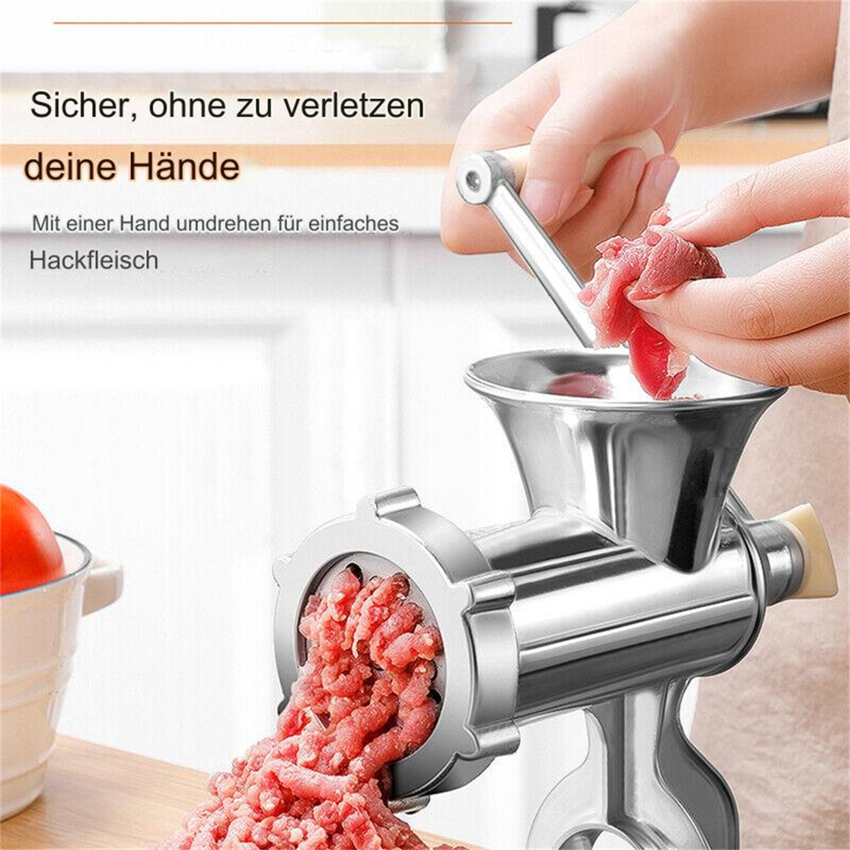 Fleischwolf, der Fleisch zerkleinert, mit einer Hand, die rohes Fleisch hält. Weißer Hintergrund.