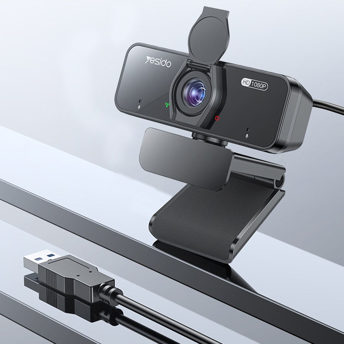 Schwarze Webcam mit eingebautem Mikrofon und USB-Kabel, auf reflektierender Oberfläche.