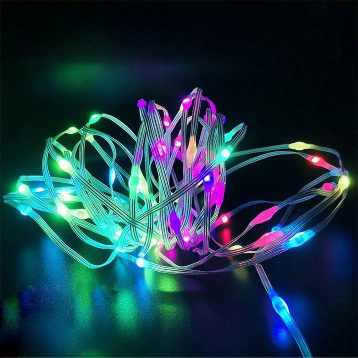 Lichterkette mit bunten LEDs. Die Lichter sind auf dunklem Hintergrund verwickelt.