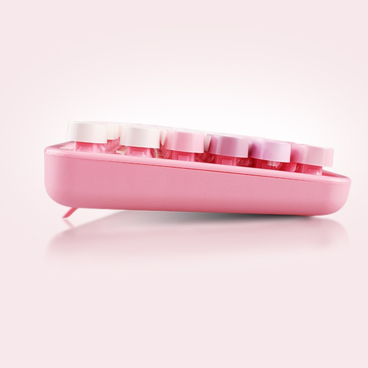 Seitenansicht einer pinkfarbenen Tastatur im Retro-Stil mit weißen und pinkfarbenen Tastenkappen.