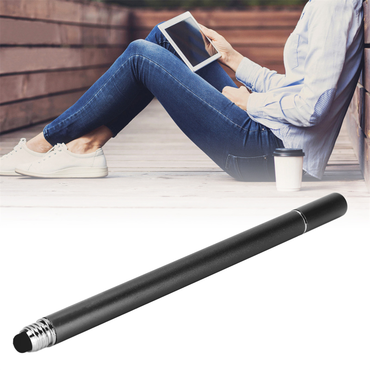 Ein schwarzer Stift auf weißem Hintergrund, im Hintergrund eine Person, die ein Tablet benutzt.