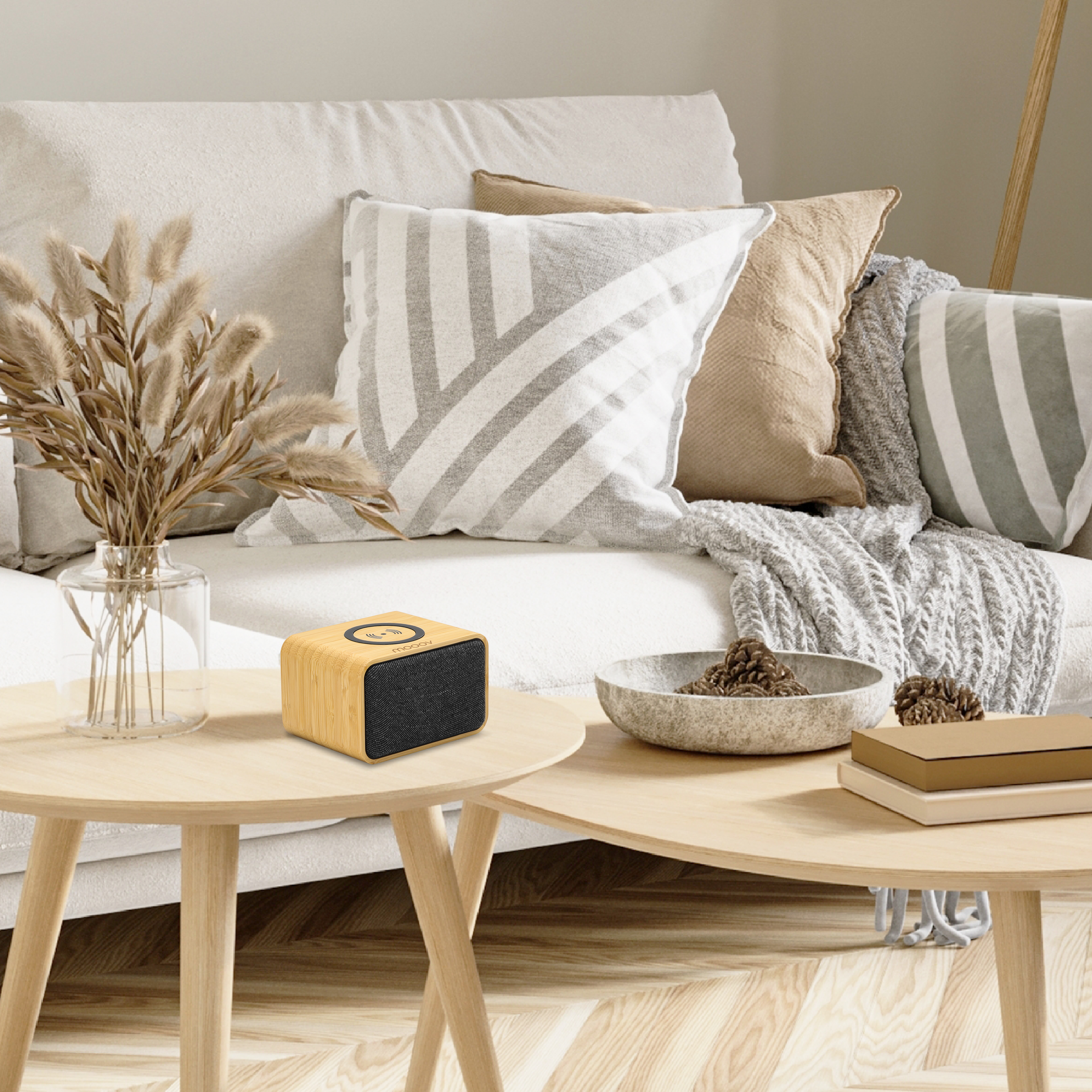 Un altavoz en una mesa con un sofá y decoración en el fondo.